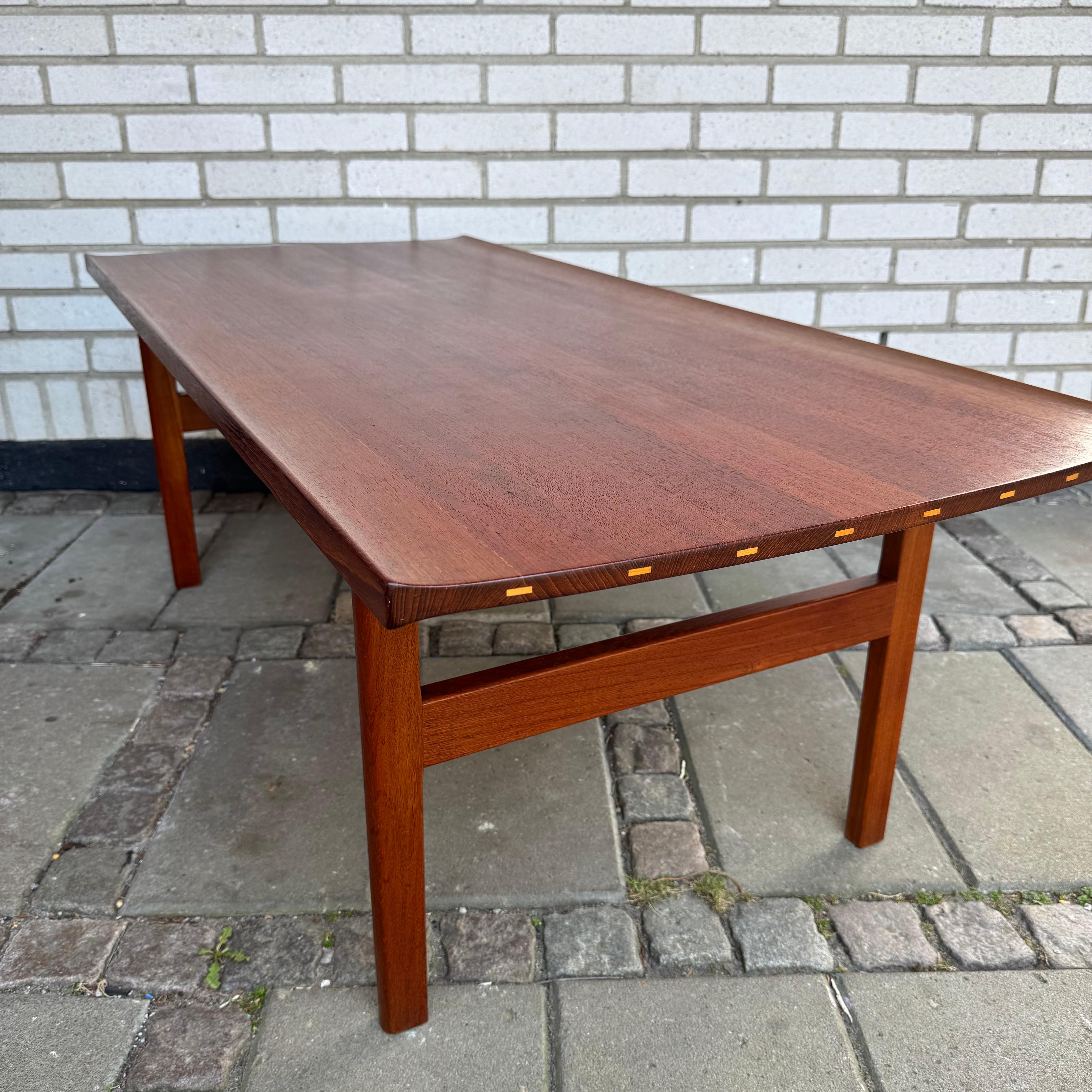The unique table designed by Tove & Edvard Kindt Larsen comes in solid teak with curved edges and elegantly inlaid plugs in lighter wood.