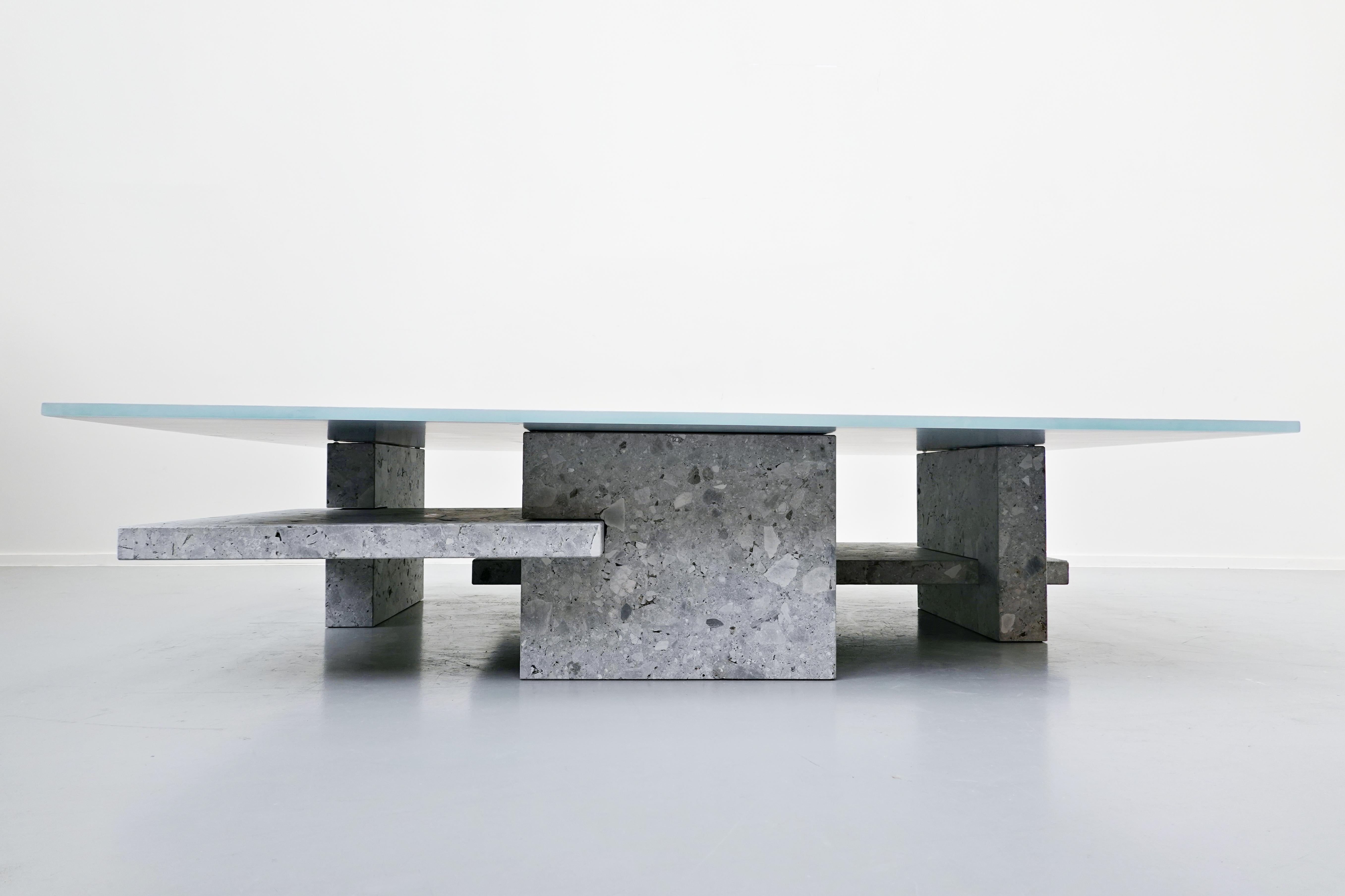 Large coffee table in Ceppo di gre and glass top, designed by Iceberg Architecture Studio.