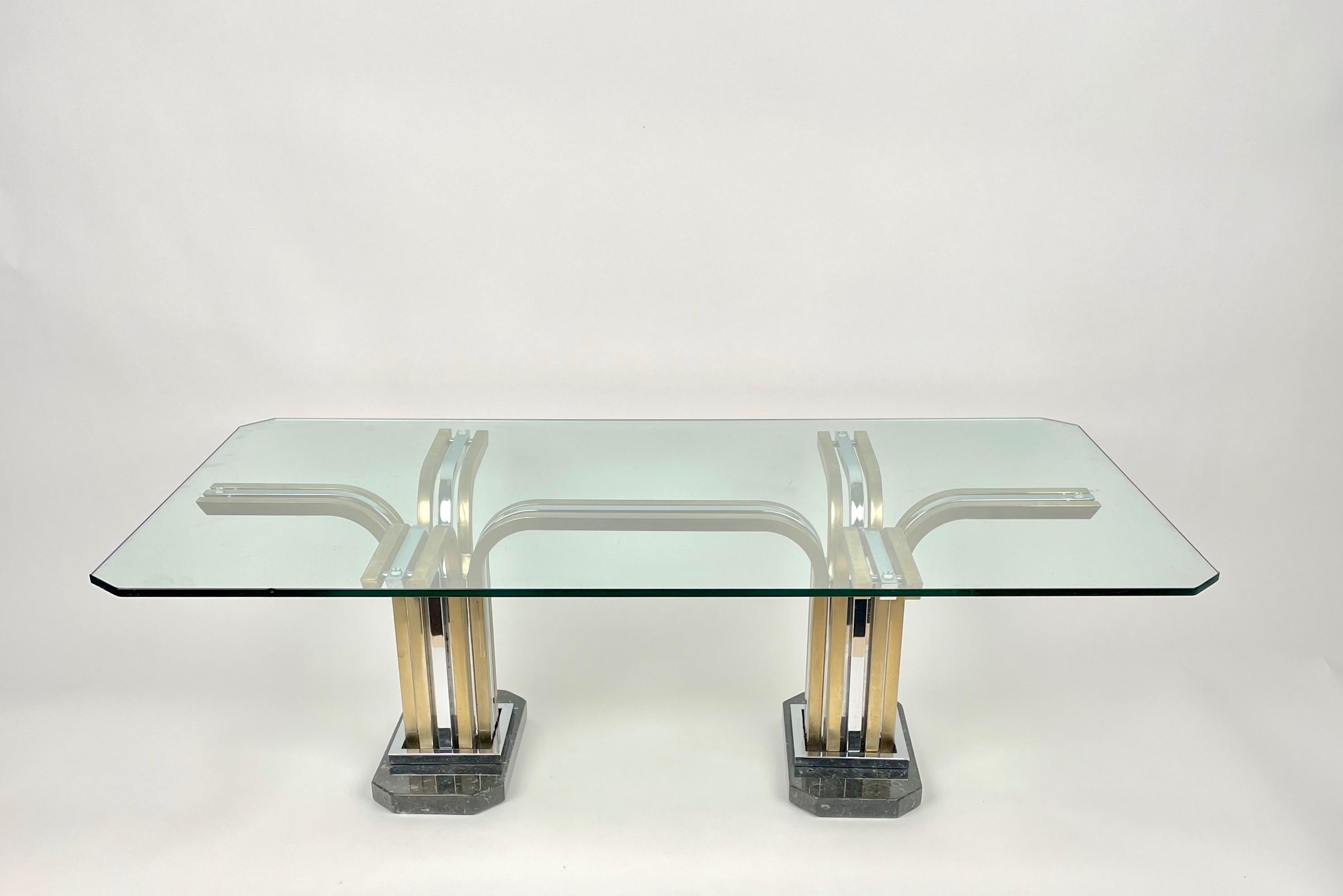 Rectangular coffee table featuring a marble base with chrome and brass legs and a glass surface in the style of the Italian designer Romeo Rega. Made in Italy in the 1970s.