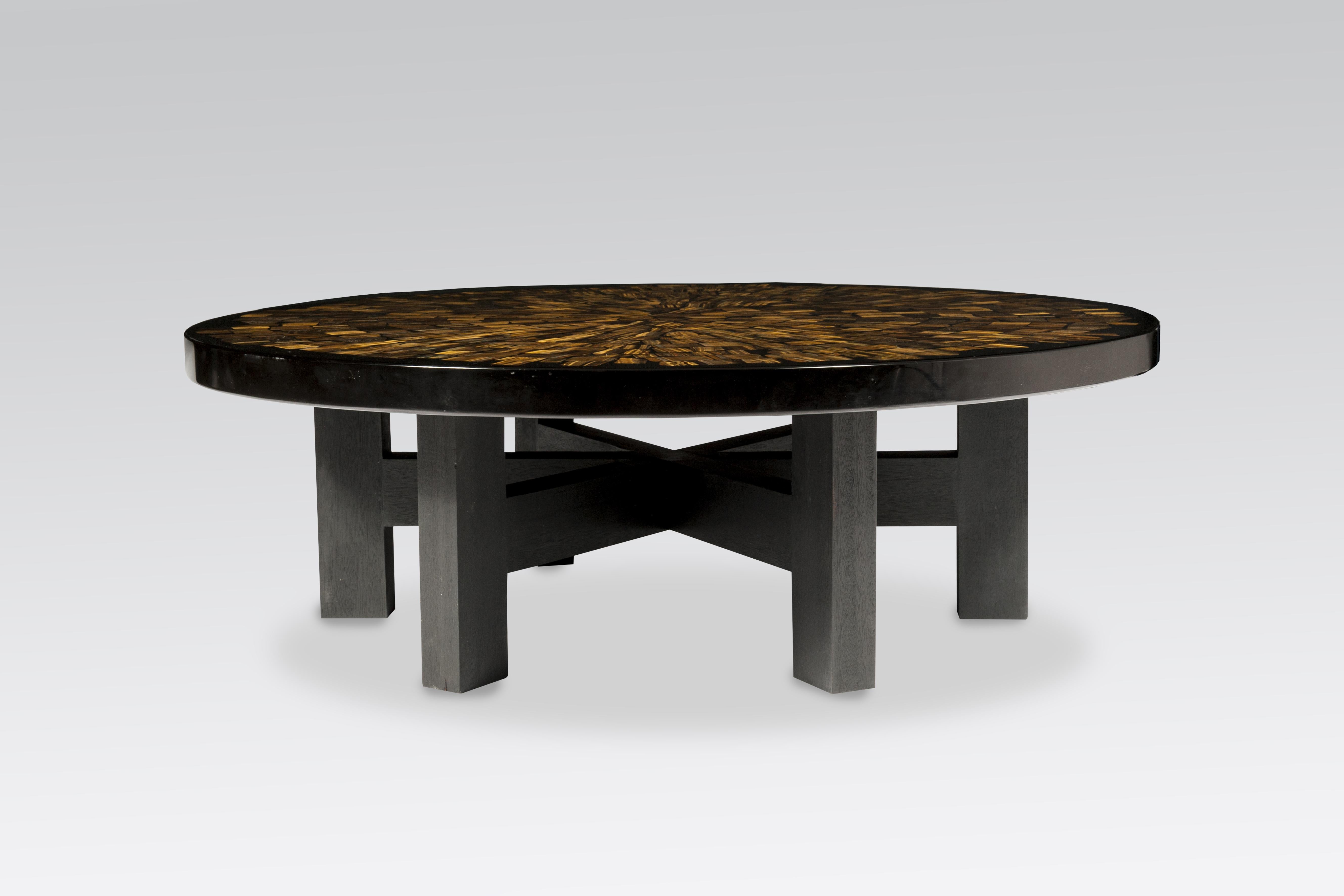This coffee table by Etienne Allemeersch, an artisan who worked in the workshop of Ado Chale, is executed circular coffee table in resin with an inlay of tiger eye wood. The piece sits on a wood black base and was produced in Belgium during the