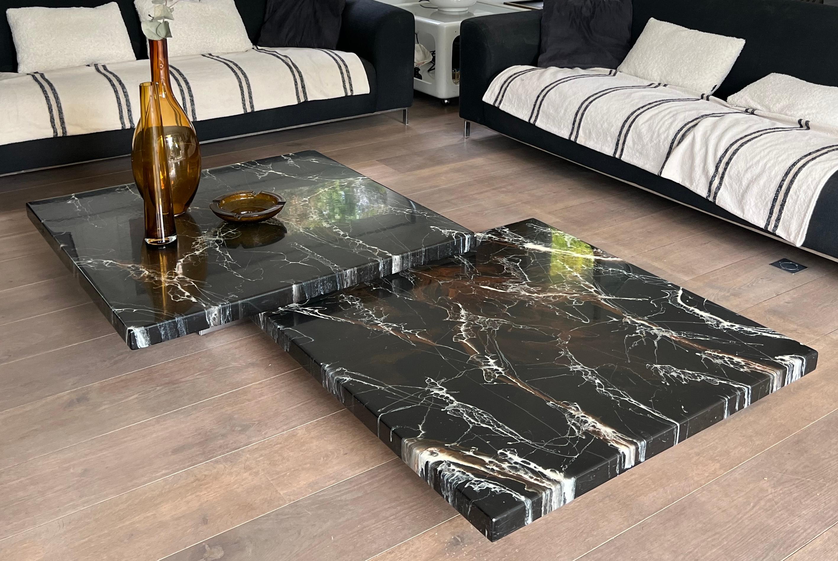 Esta rara y bella mesa de centro de diseño está compuesta por dos tableros de resina de imitación de mármol y descansa sobre dos discretas patas cromadas de diferentes alturas que dan la impresión de que los tableros están suspendidos en el aire.