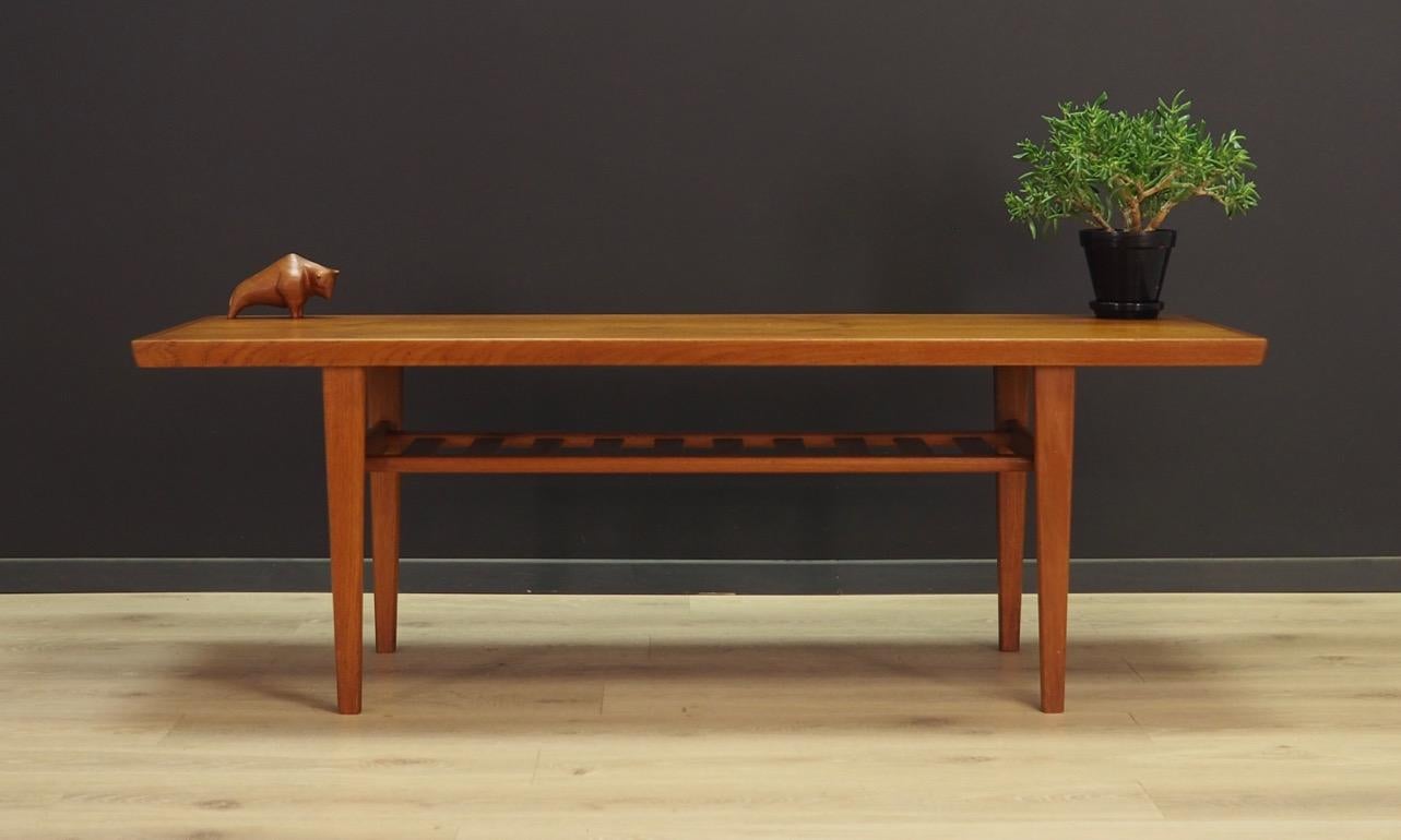 A great coffee table from the 1960s-1970s. Danish design, minimalistic form. Tabletop surface covered with teak veneer, legs made of solid teak wood. Maintained in good condition (minor bruises and scratches, filled veneer cavity), directly to