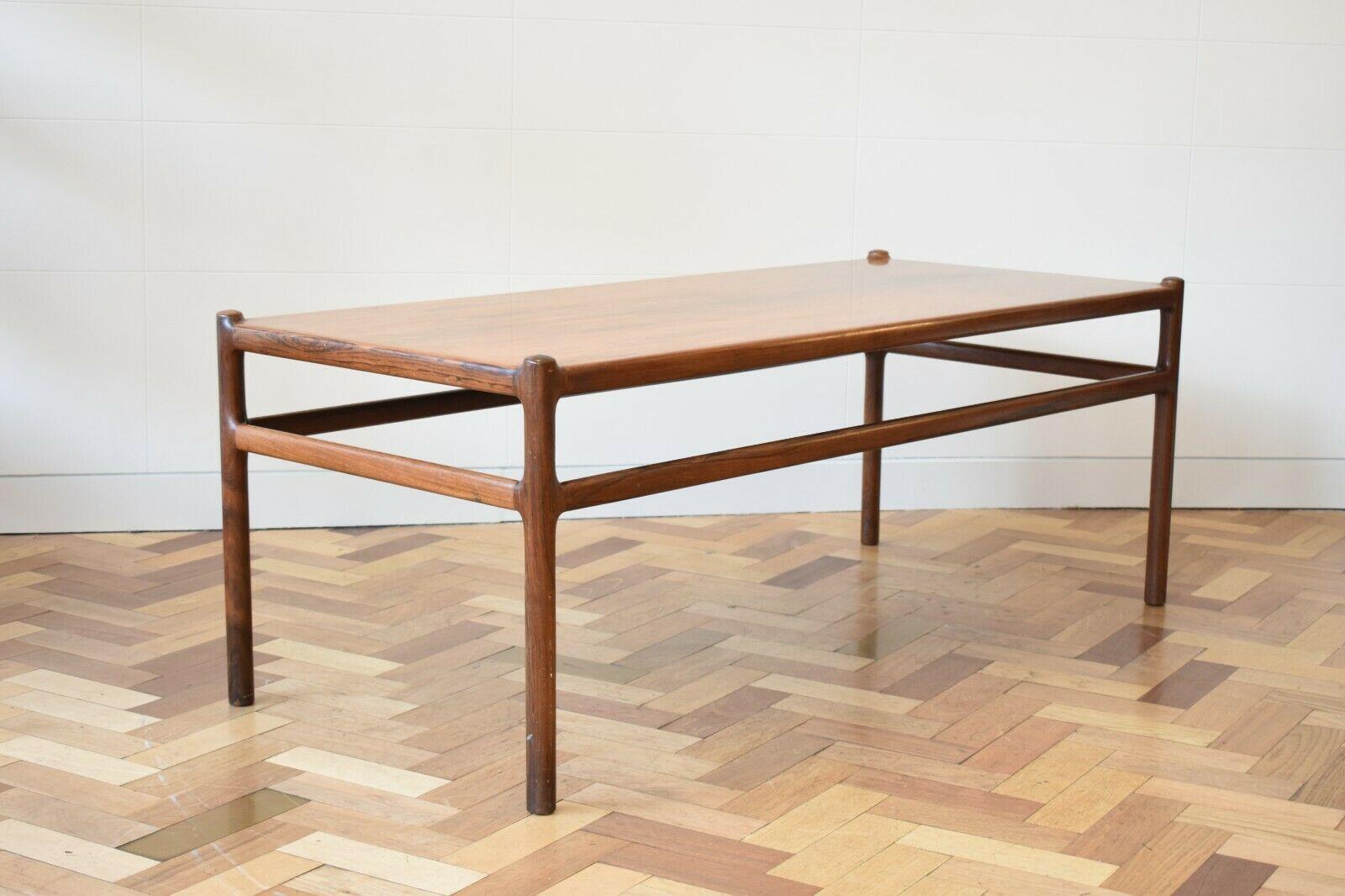 Sleek rosewood coffee table by Henning Korch for CF Christiansen Silkeborg. This 1960s piece offers the simplistic beauty of Danish design, featuring tall slim legs with protruding mounds at the corners of the table’s top.

 