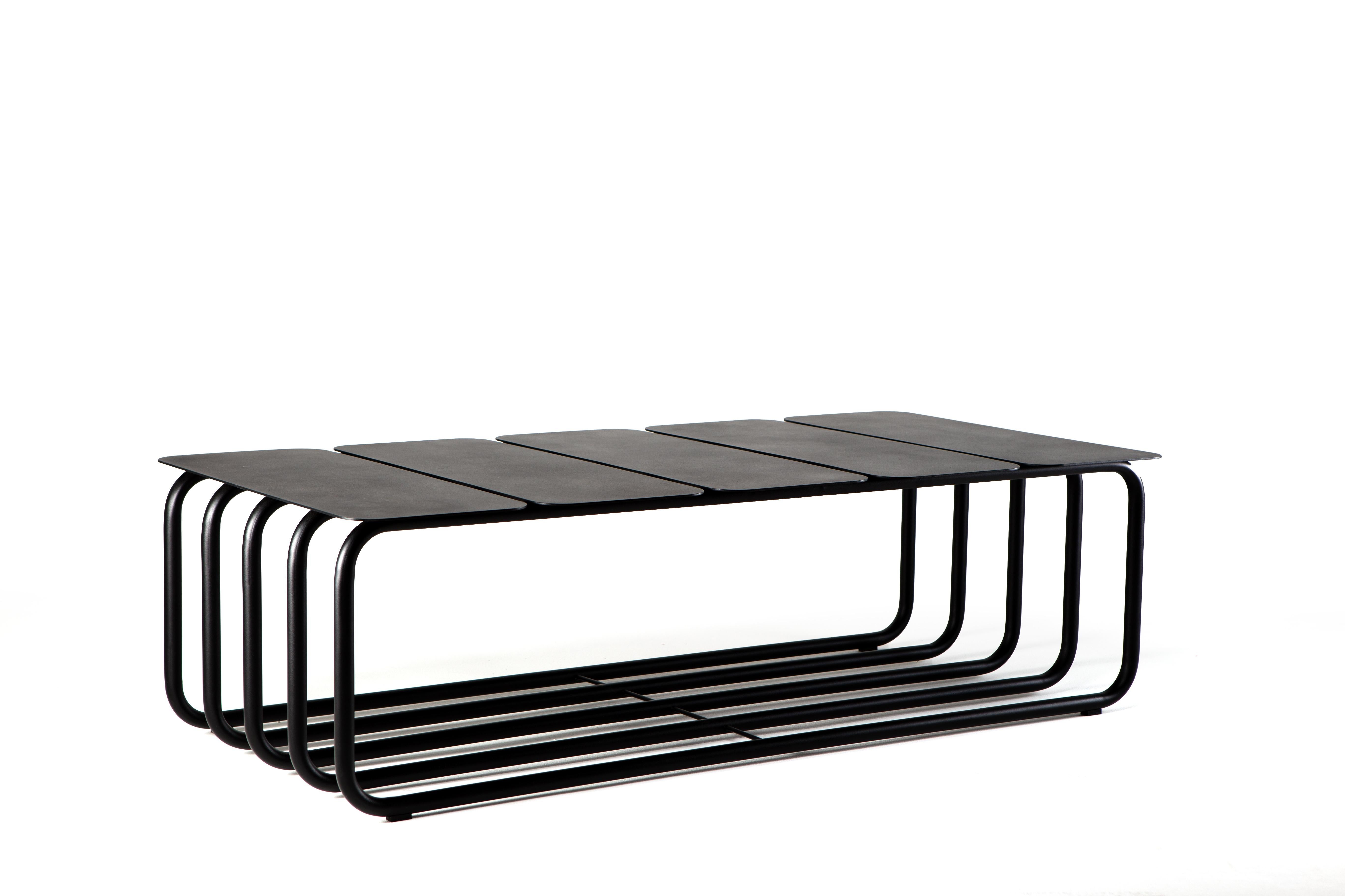 The coffee table is part of the Dureza collection. Carbon steel reigns as raw material, guiding both simple and rigorous forms, and the graphic language of this new series. The solid and geometric character of the metal plates dialogues with the