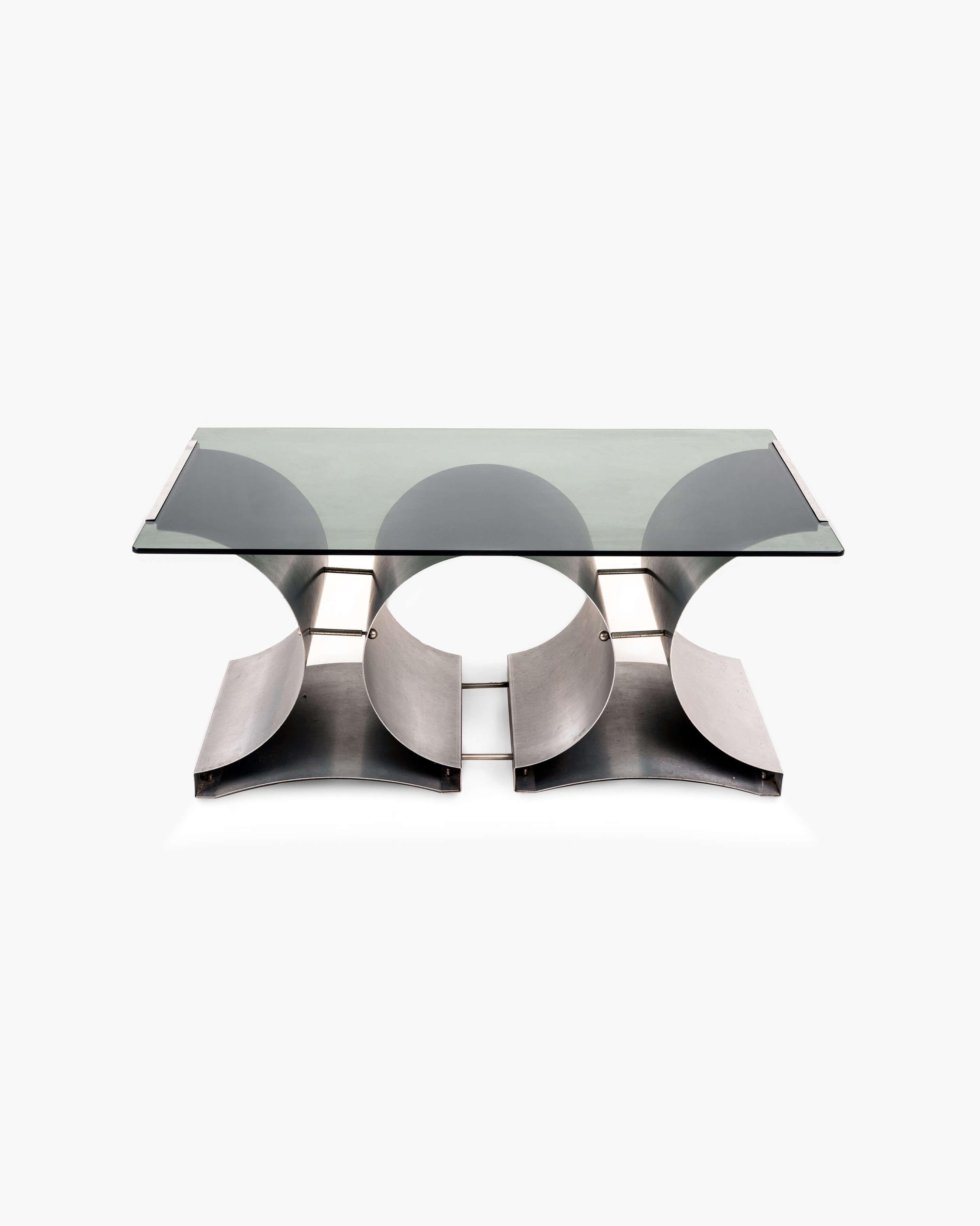 Experience the remarkable design of Francois Monnet with this coffee table for Kappa. Crafted in the 1970s, this table features a striking smoked glass top that perfectly complements its sleek steel base.

The tensioned steel sheets form a