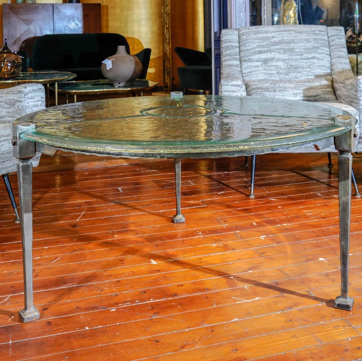 Round coffee table with a brass base, plate made with a glass block.