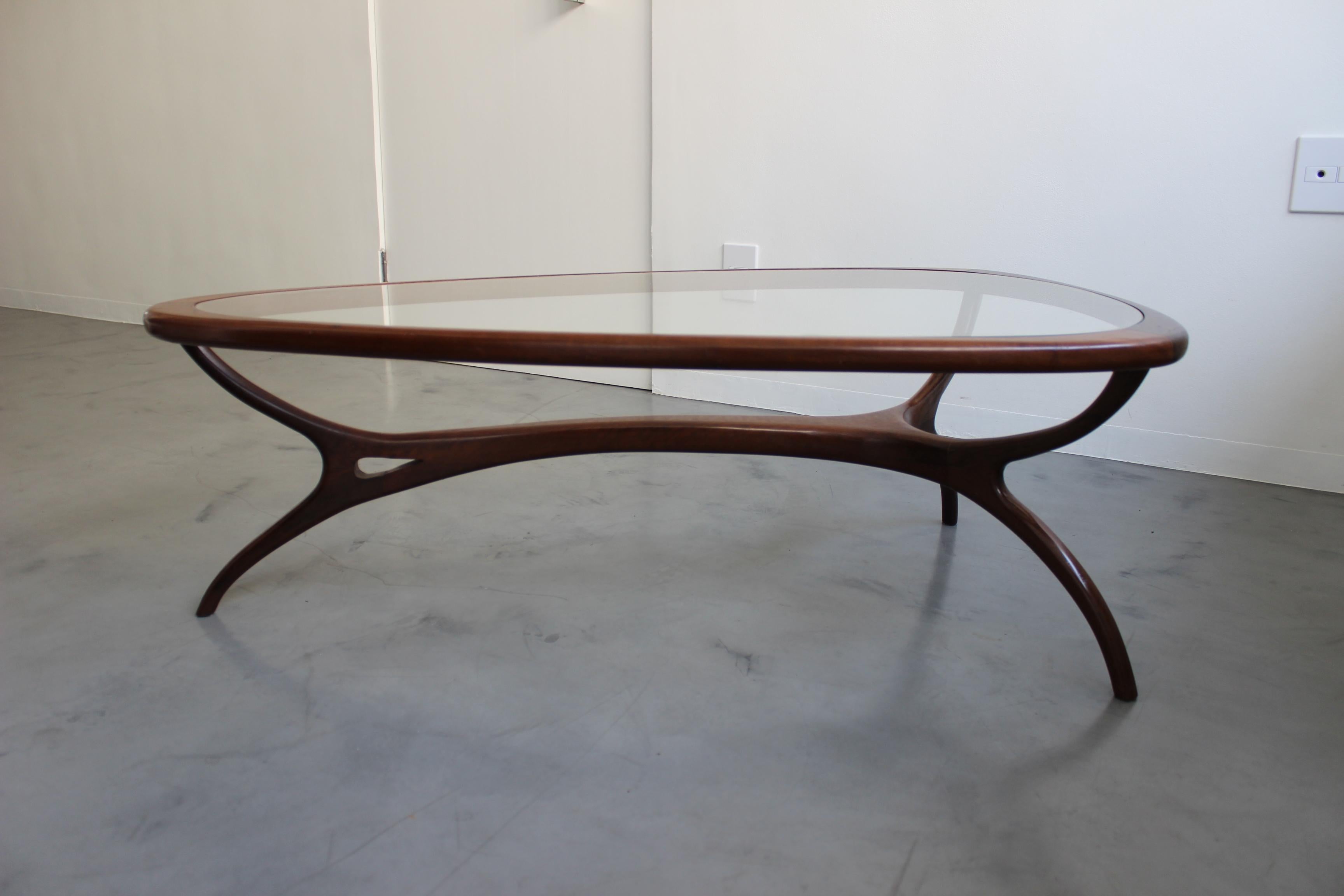 Beautiful sensual wooden curves and glass produce a sculptural coffee table by Italian-Brazilian Modern master Giuseppe Scapinelli