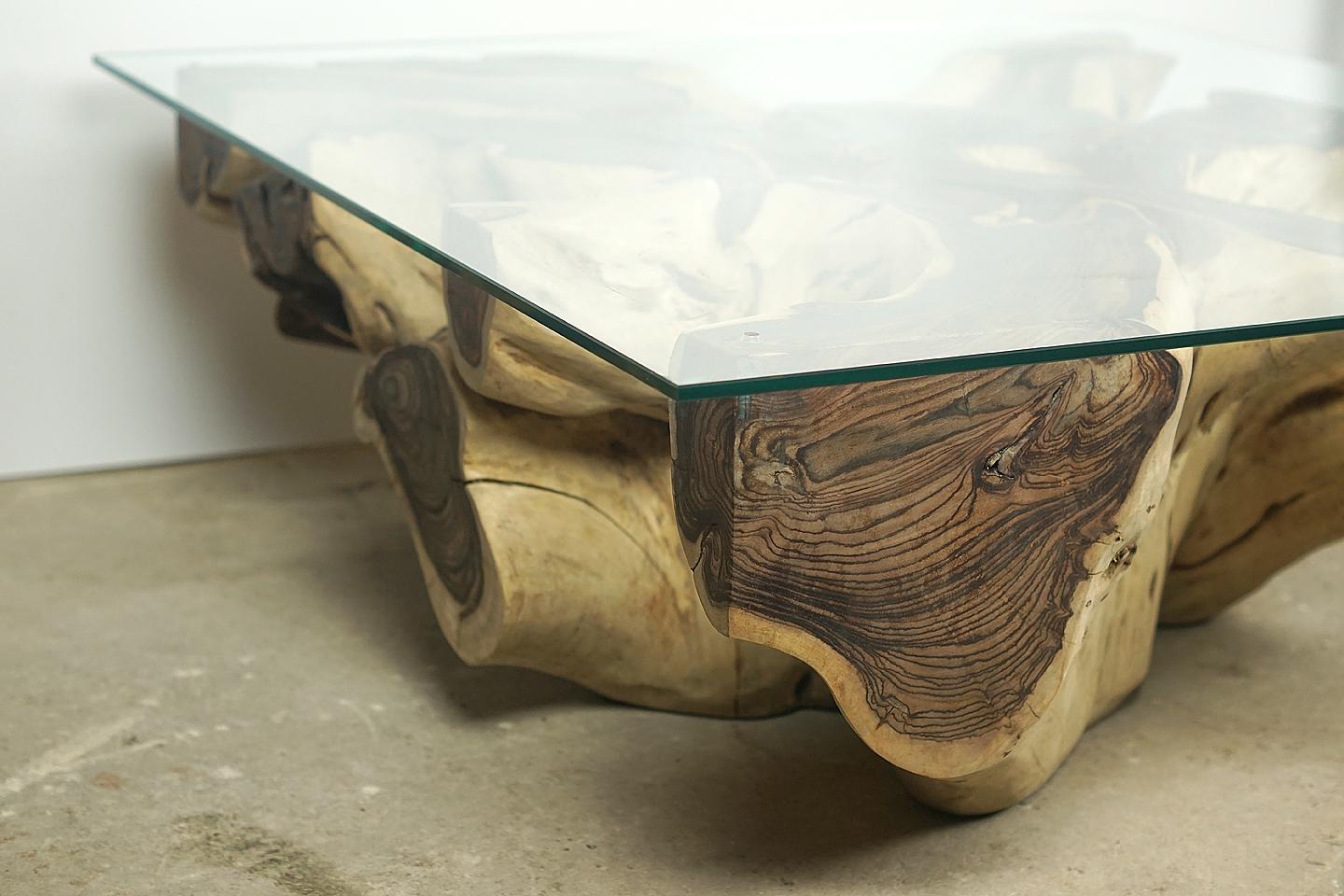 Coffee table from sonokiling root

Beautiful organic sonokiling root coffee table with stunning erosion detail, with a tempered glass plate (10mm) on the top. Oiling the root gives its special unique finish.
