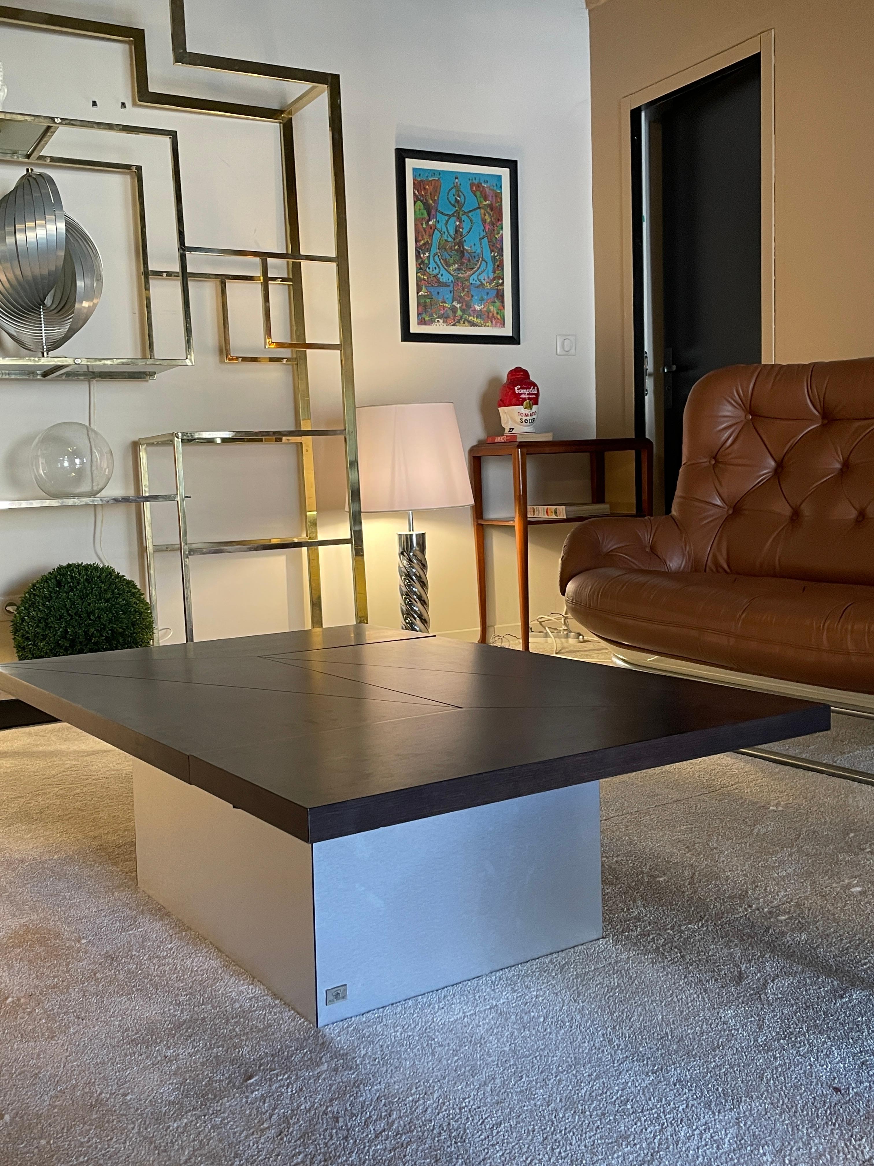 Coffee table with dry bar designed by Paul Michel. 1970s. France. The table slides open to reveal a hidden mirrored dry bar with storage for four bottles and a glass shelf. The outside of the base in brushed steel is in perfect condition. Beautiful