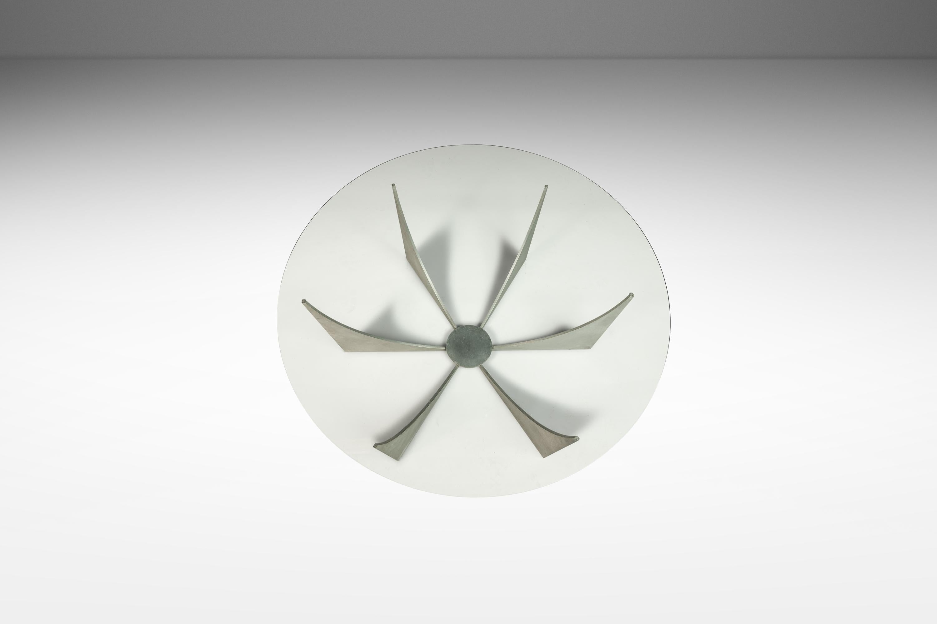 Cette captivante table basse d'inspiration Brasilia, attribuée à Donald Drumm, incarne l'énergie brute et expressive du design brutaliste des années 1960. Soudé à la main à partir d'aluminium massif, le socle présente une composition géométrique