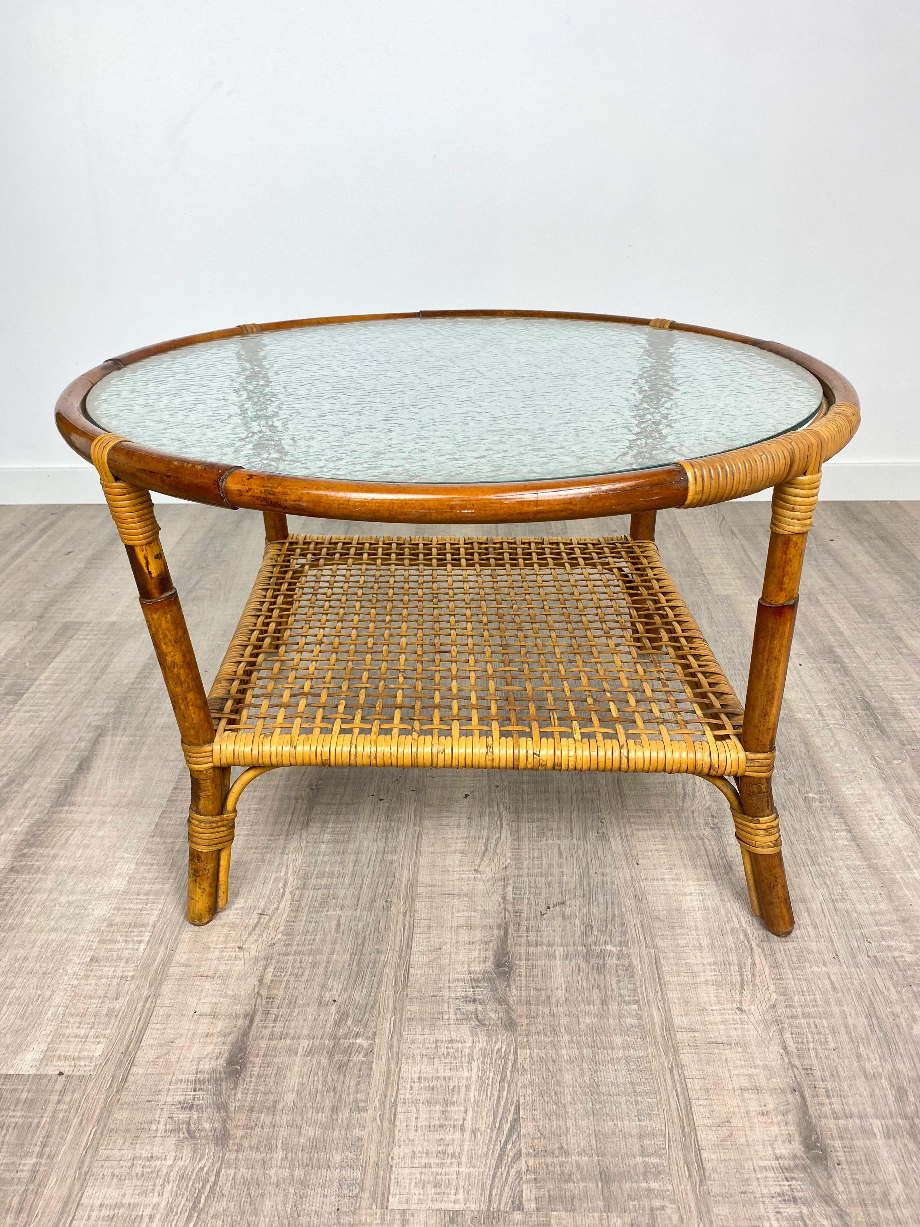 Round coffee table in a bamboo structure featuring a frosted glass surface and a lower netting shelf in bamboo, Italy, circa 1960.