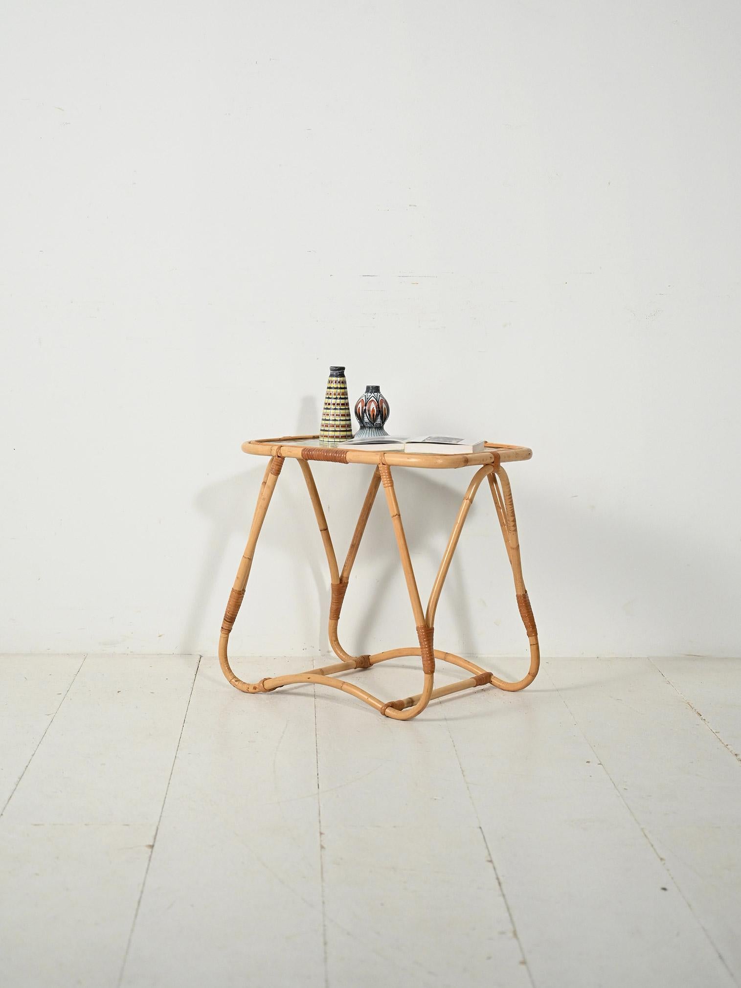 Piccolo coffee table anni '60 in bambù curvato, gambe dal profilo organico e piano in vetro opaco incassato.

Forma leggera in bambù curvato con legature a vista e base continua ad anello che disegna gambe arrotondate dalla forma organica. Le sommet