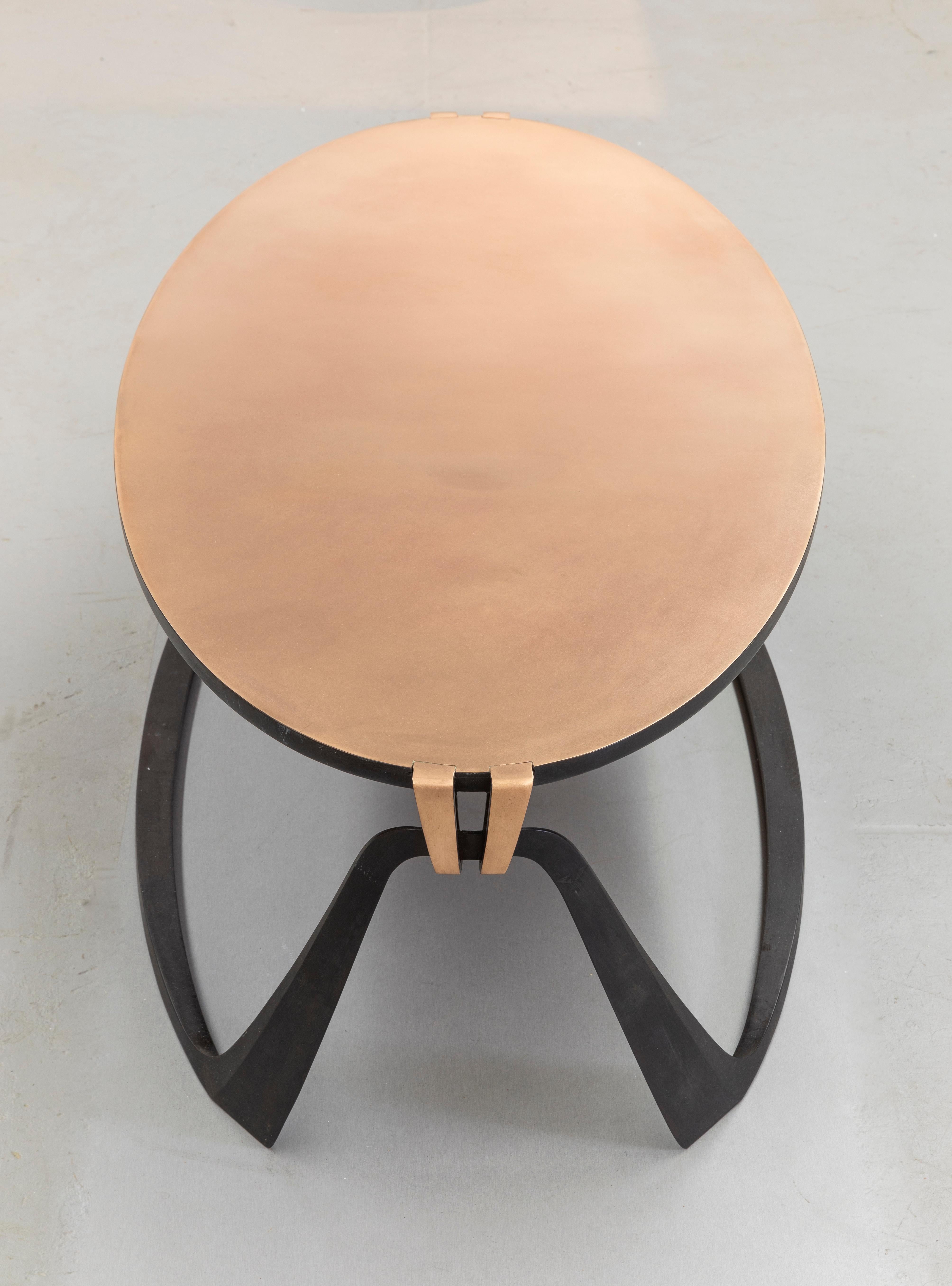 Elegante table basse en bronze bicolore.
Influencée par ses études de stylisme, Anasthasia Millot crée des formes subtilement dynamiques qui semblent défier la statique des matériaux solides.
Les courbes, les touches ascendantes et descendantes de