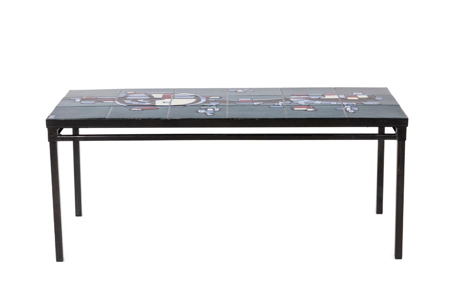 Coffee table. Tray in ceramic, abstract but suggesting a character. Base in black lacquered iron.

French work realized in the 1950s.