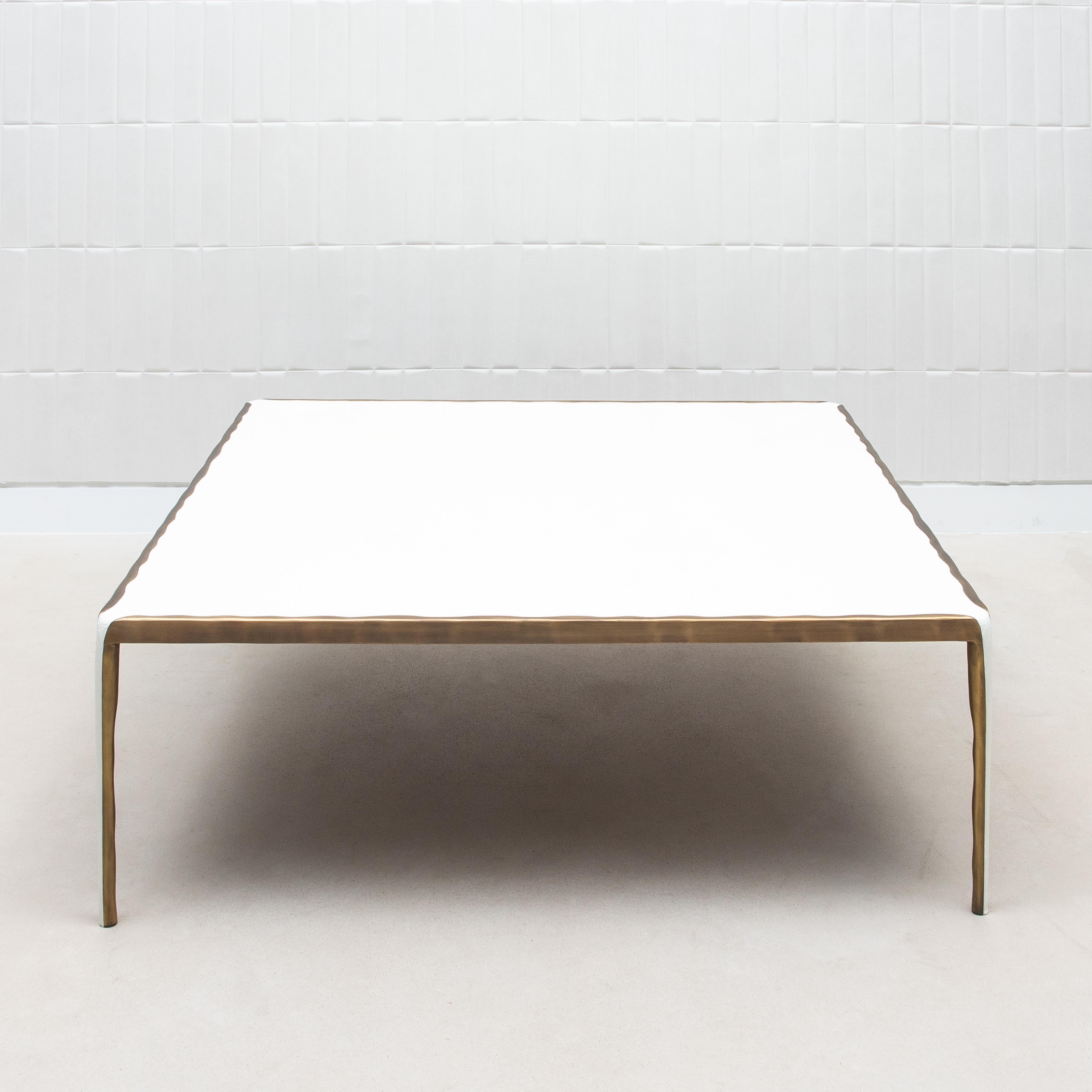 La table basse Square Melting de R&Y Augousti est une pièce sublime qui allie sans effort la fluidité des formes organiques à l'élégance intemporelle des matériaux luxueux. Son plateau, fabriqué en galuchat crème, offre une surface douce et tactile
