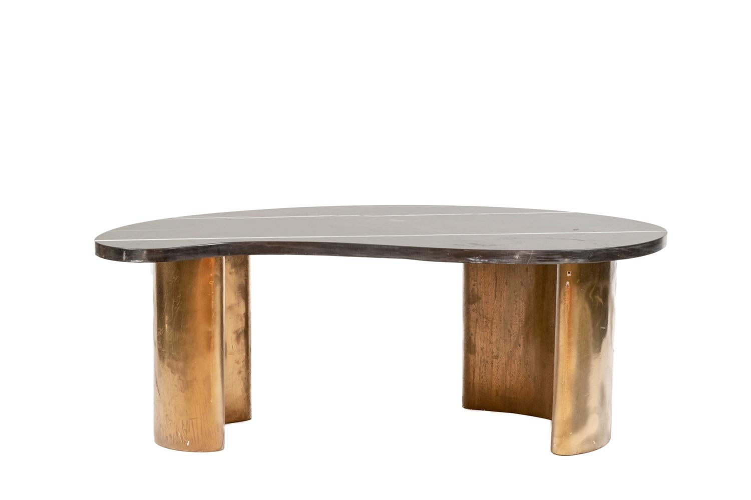 Coffee table, bean-shaped. White veined marble top, black. Base in matt golden brass.

Work realized in the 1980s.