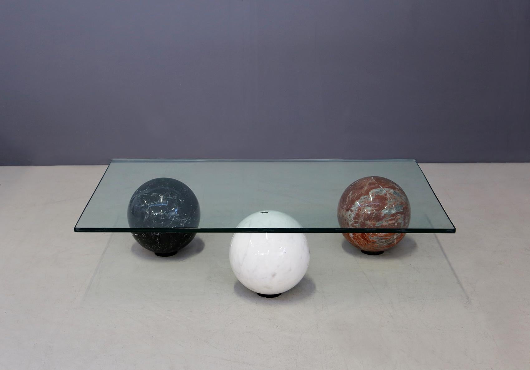 Elegant and modern coffee table made by the prestigious Italian manufacturer Cattelan Italia, with the brand engraved in brass on the white sphere. The coffee table is made with three different marble spheres, Carrara white, black, and burgundy red.