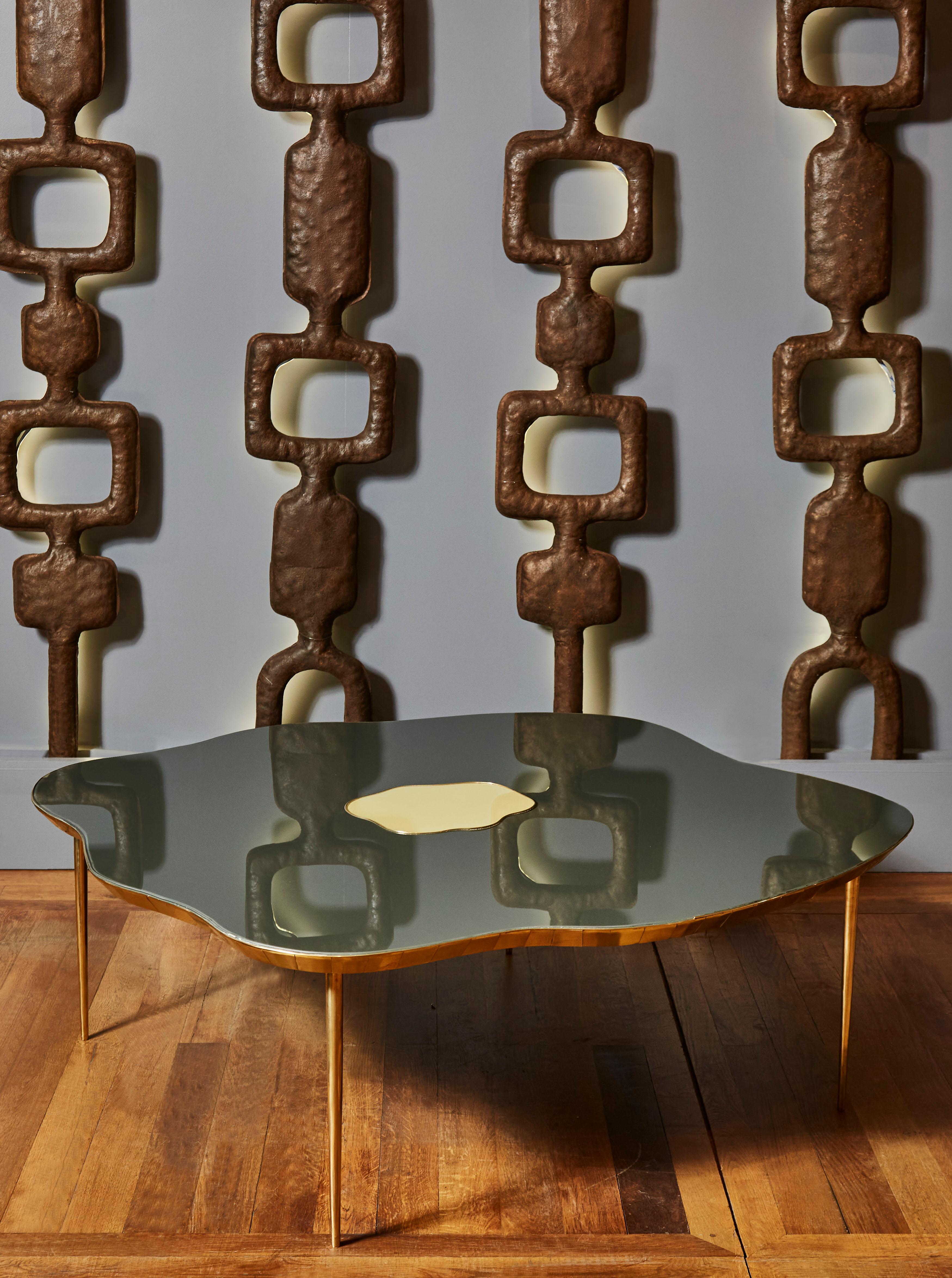 Free-shape coffee table in tainted mirror top with brass inlays, and brass legs. Creation by Studio Glustin.
Height and colors can be custom.