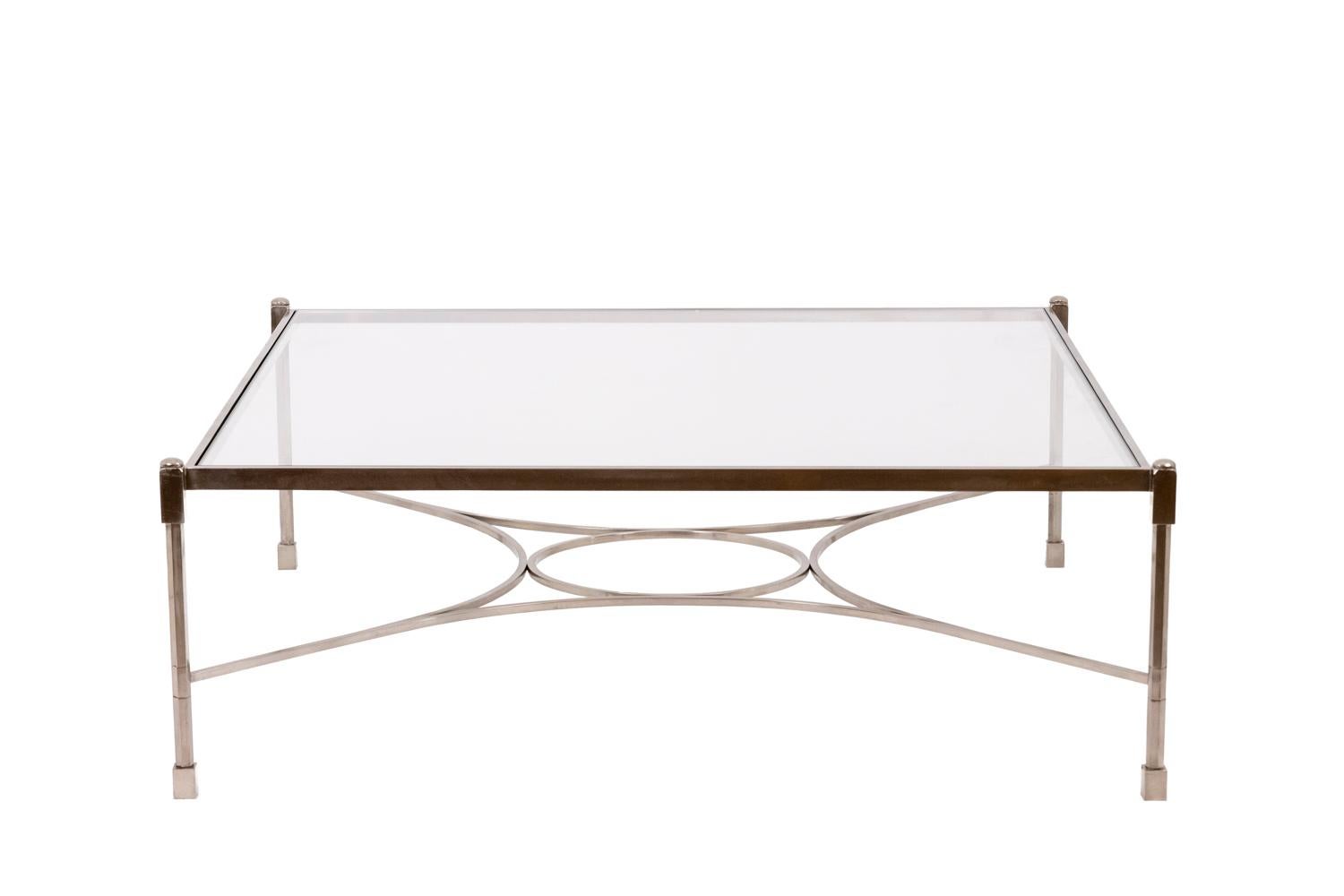 Coffee table. Base in nickel-plated steel, square shape. Glass top. Spacer consisting of a circle and four half-moons.

French work realized in the 1970s.
 