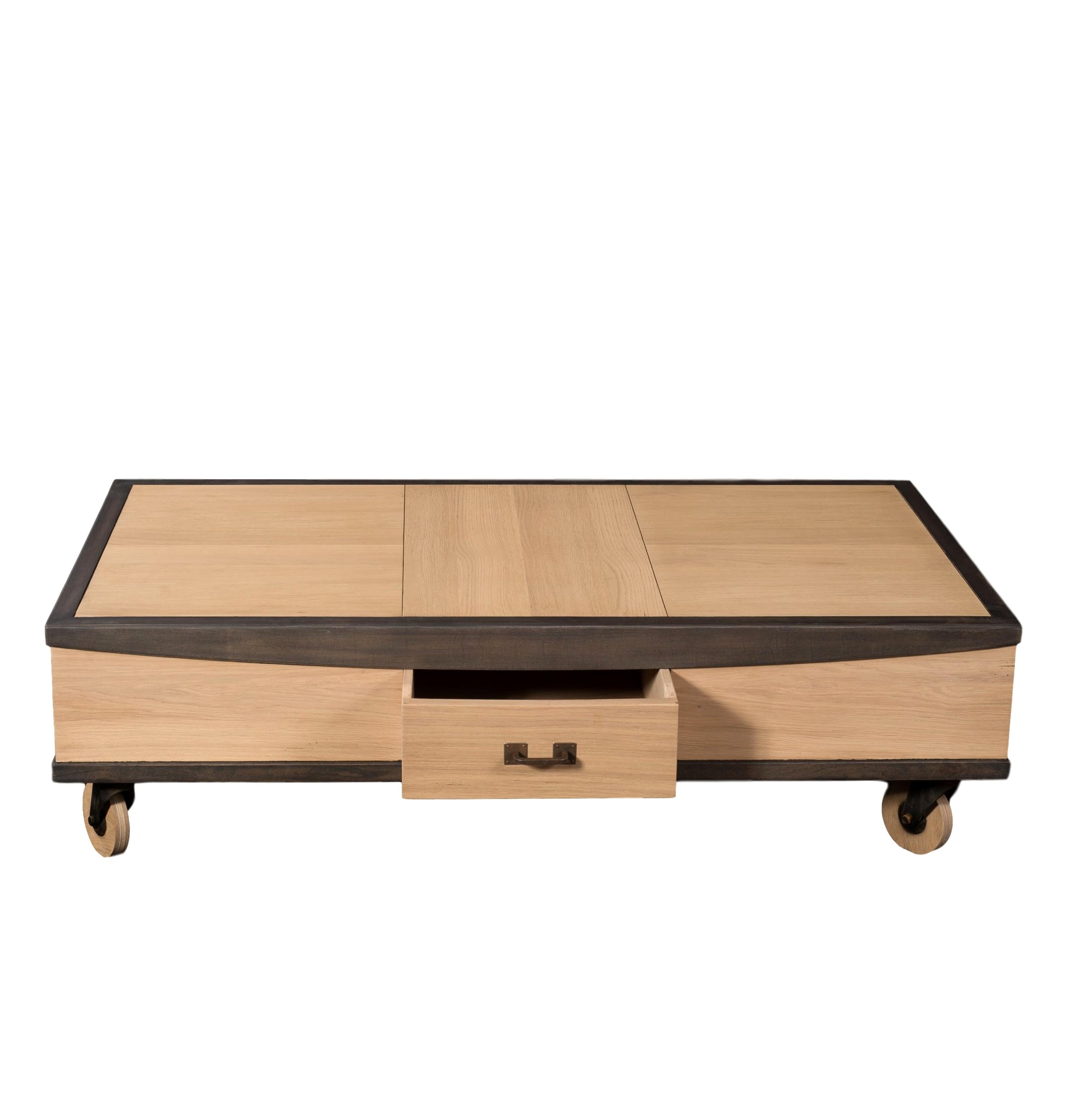 This coffee table is in oak and designed by the French Designer Christophe Lecomte.

The 4 small wheels are in wood 
1 small drawer at the front with a bakc and forth motion
3 layers finish including a whitened oak stain and a stain that