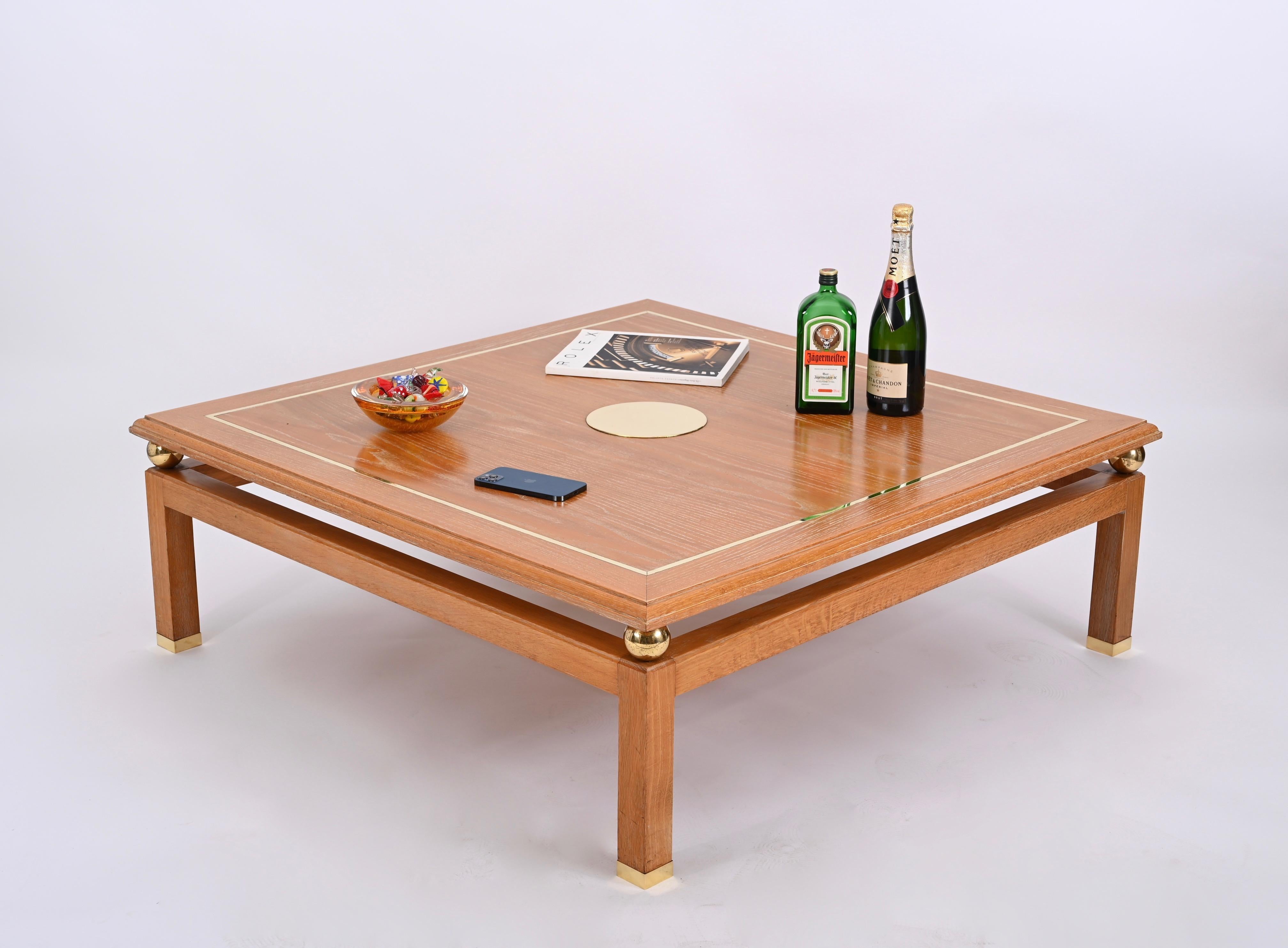 Magnifique table basse carrée en bois de chêne et laiton signée par Tommaso Barbi et produite dans les années 1970 en Italie. 

Cette pièce unique présente une belle structure en bois de chêne plaqué et ciré, le plateau est décoré d'un cadre en