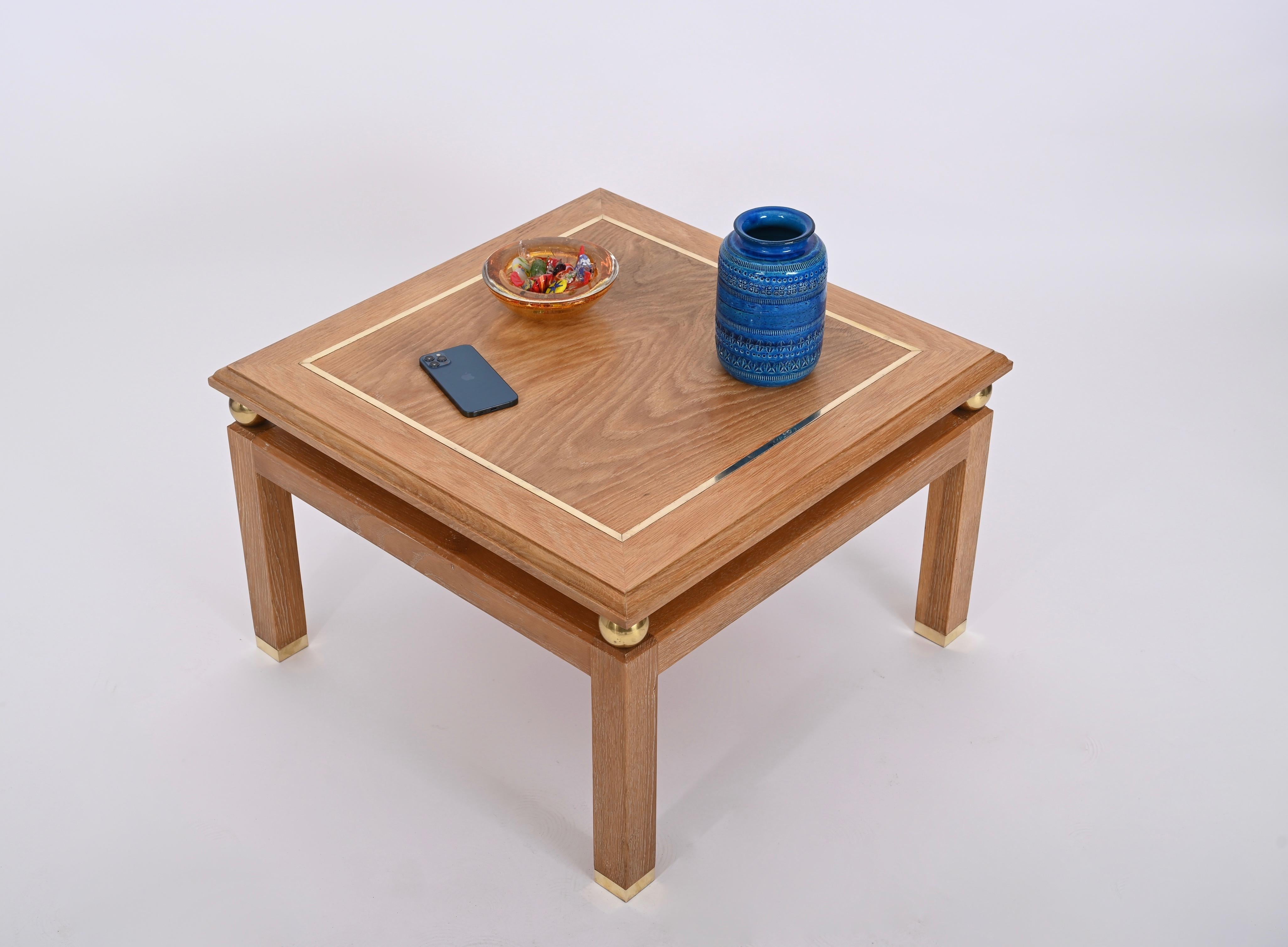 Magnifique table basse carrée en bois de chêne et laiton signée par Tommaso Barbi et produite dans les années 1970 en Italie. 

Cette pièce unique présente une magnifique structure en bois de chêne plaqué et ciré. Le plateau est décoré d'un cadre