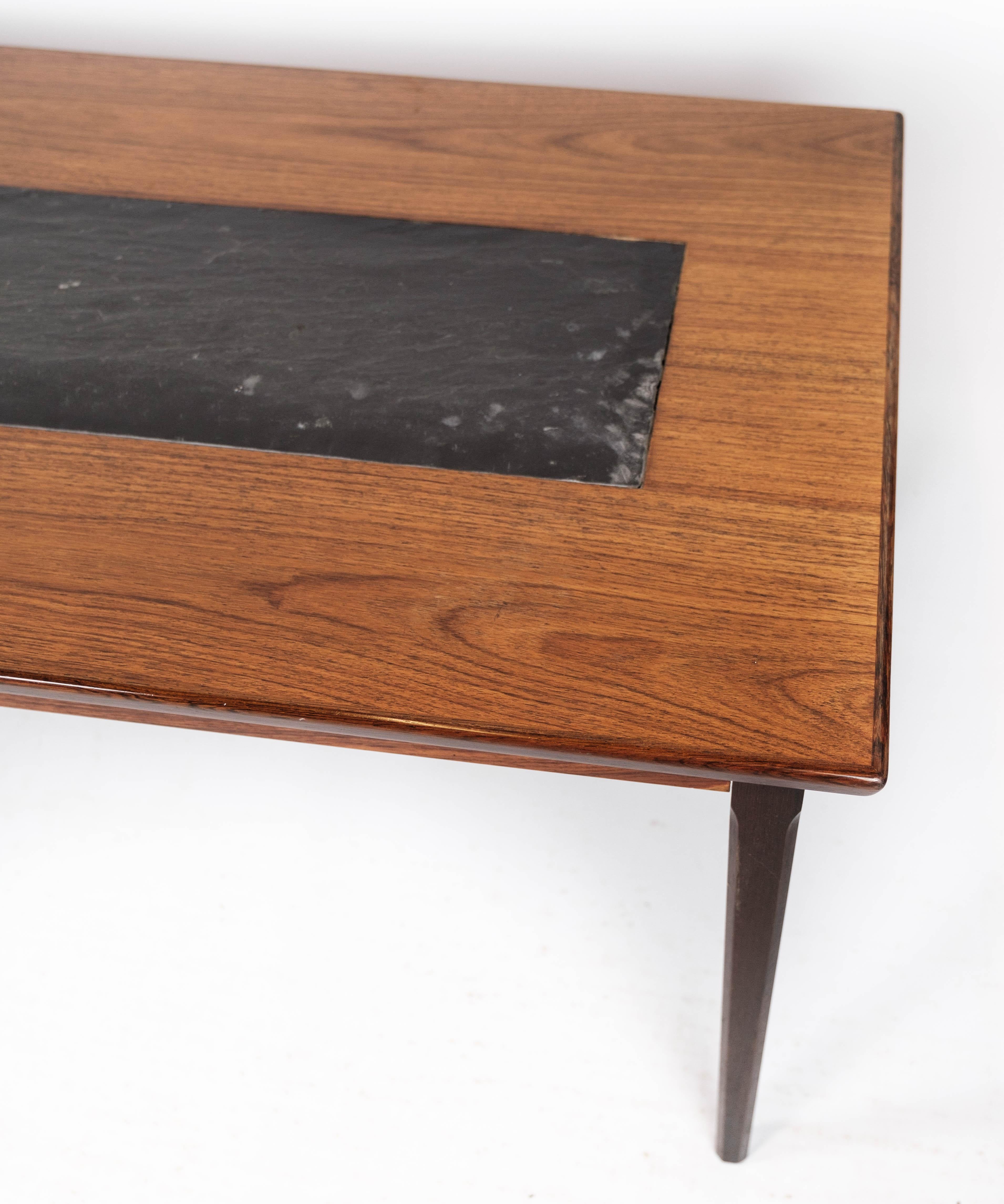 The coffee table, crafted from rosewood and black slate and of Danish design from the 1960s, is a striking example of mid-century modern craftsmanship.

Combining the rich tones of rosewood with the sleek sophistication of black slate, this table