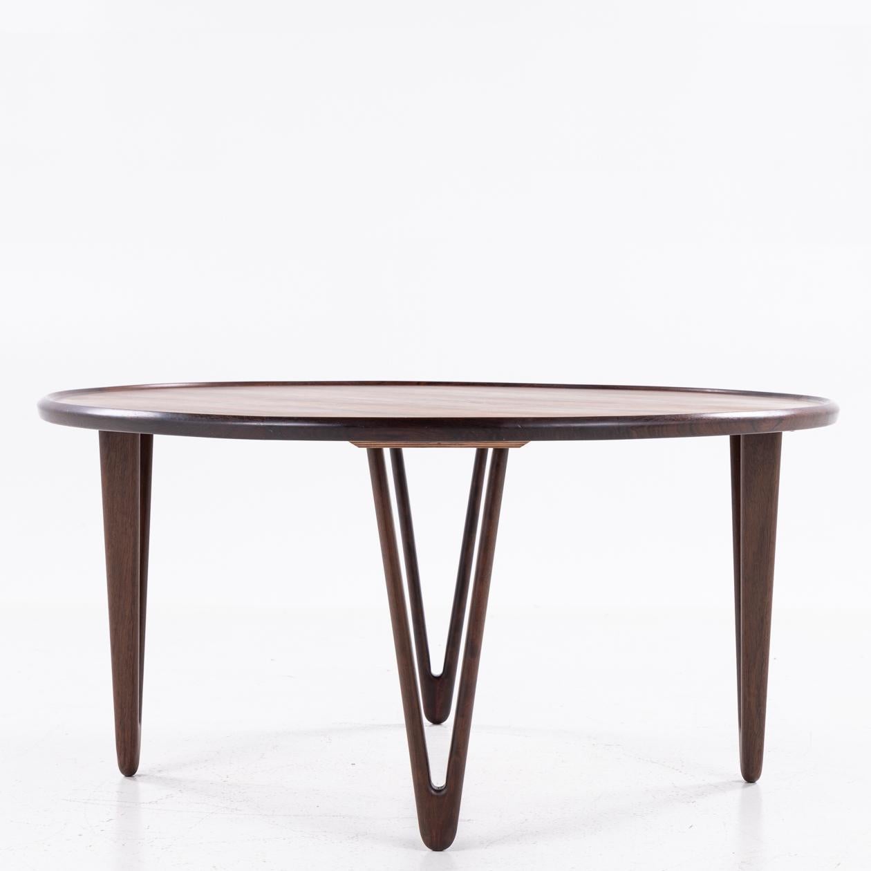 Mesa de centro redonda de palisandro con patas en forma de V.