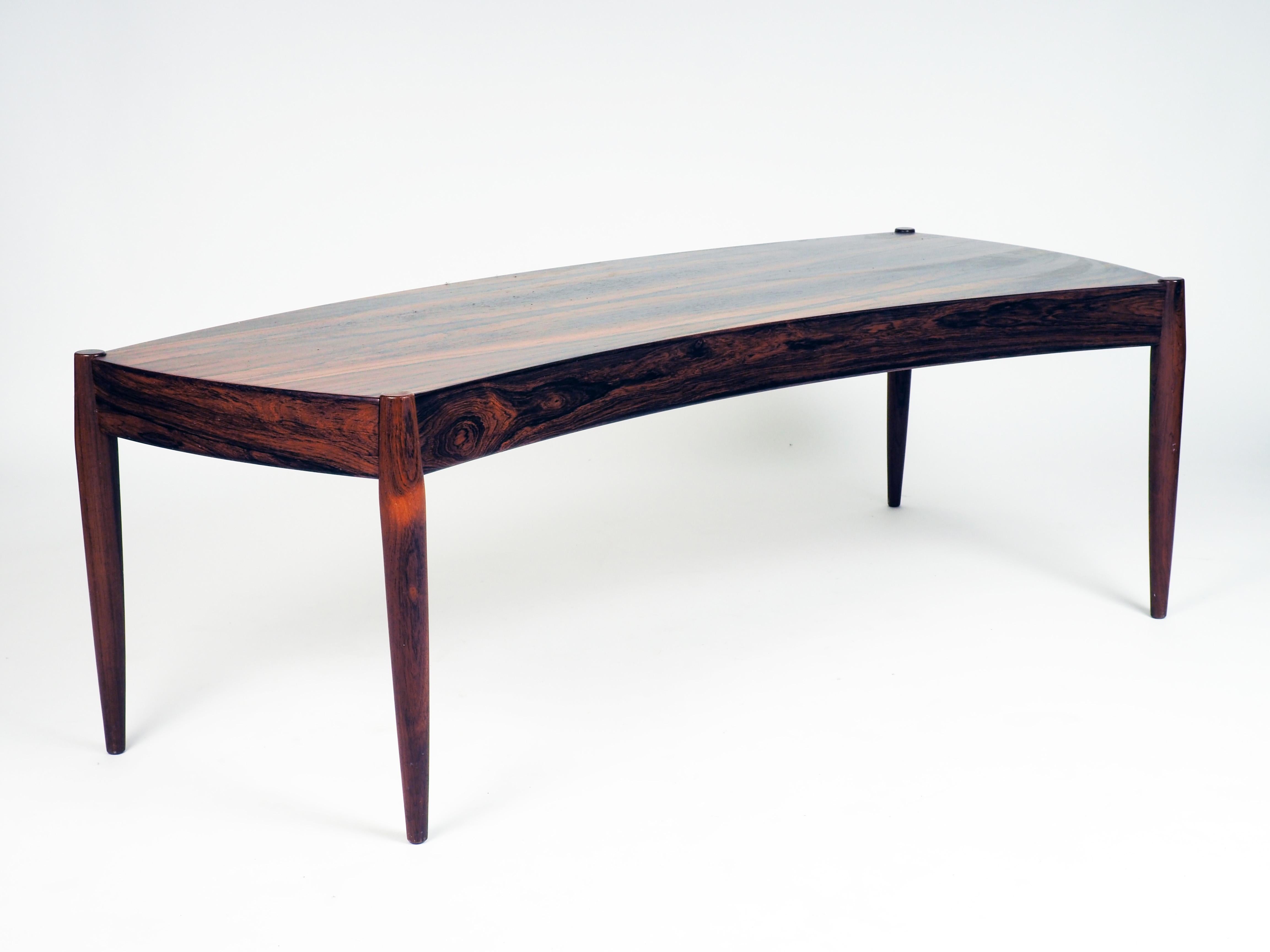 Coffee table in bent shape. Made in rosewood by Trensum, Sweden. The table was designed by the Danish architect Johannes Andersen.