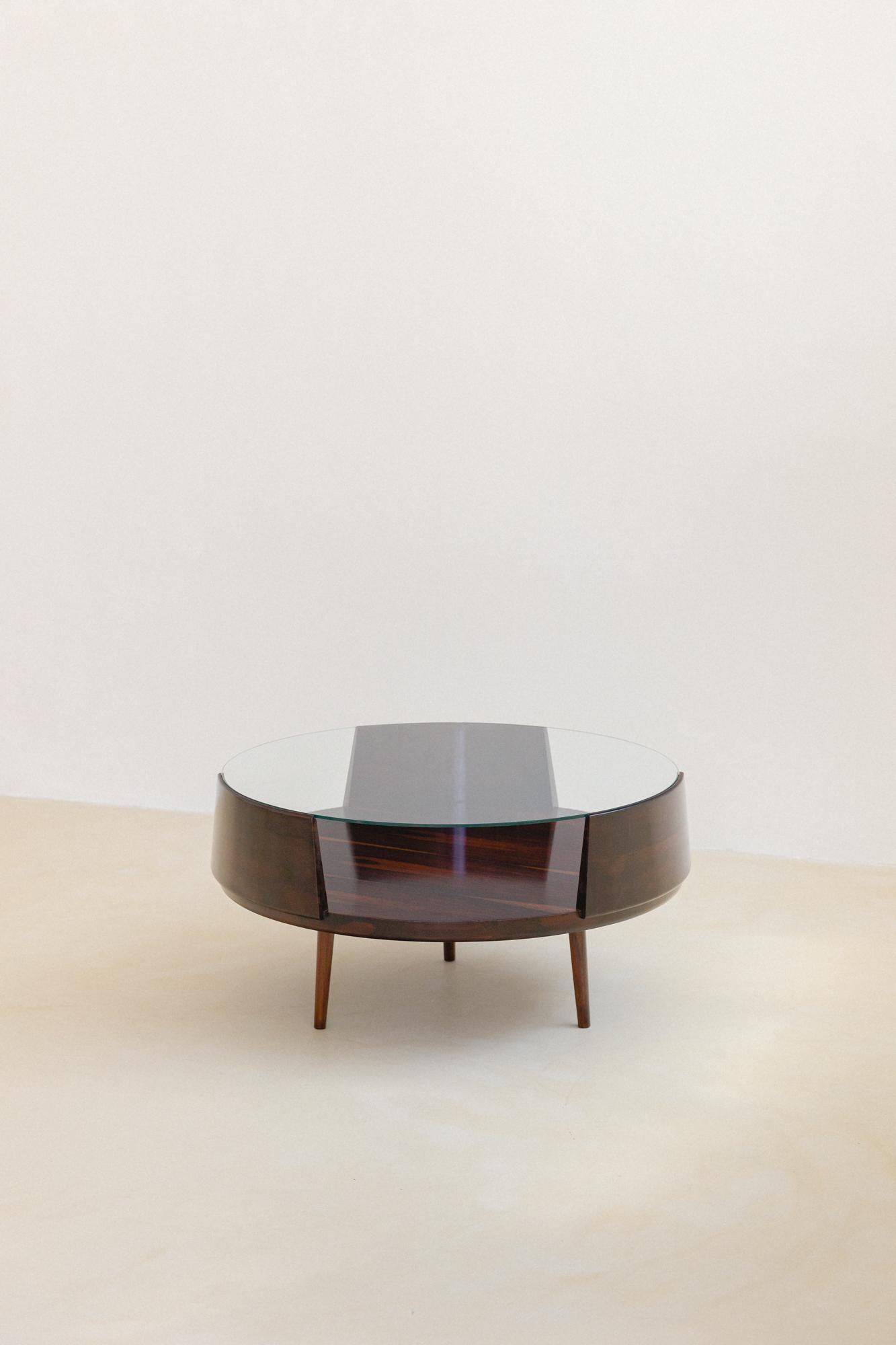 Esta mesa de centro redonda de palisandro fue diseñada por Martin Eisler (1913-1977) y Susi Aczel (1931-) para Forma S.A. Móveis e Objetos de Arte.

Esta pieza es una de las más icónicas de la obra diseñada por Martin Eisler, y remite a una