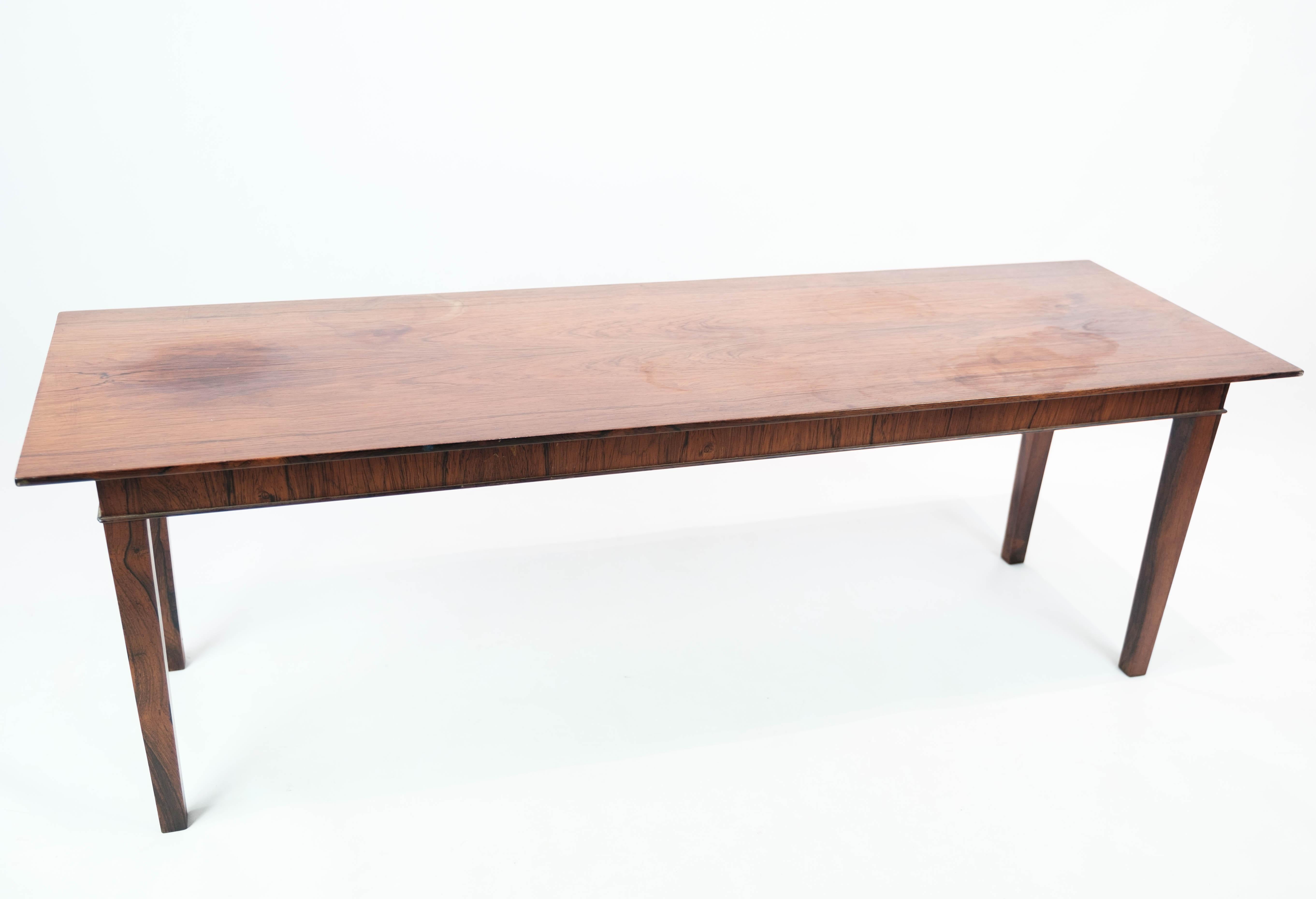 This rosewood coffee table is a beautiful example of Danish design from the 1960s. The table exudes a timeless elegance and is in nice used condition, which reflects its quality and durability.

The deep color and beautiful wood patterns of rosewood