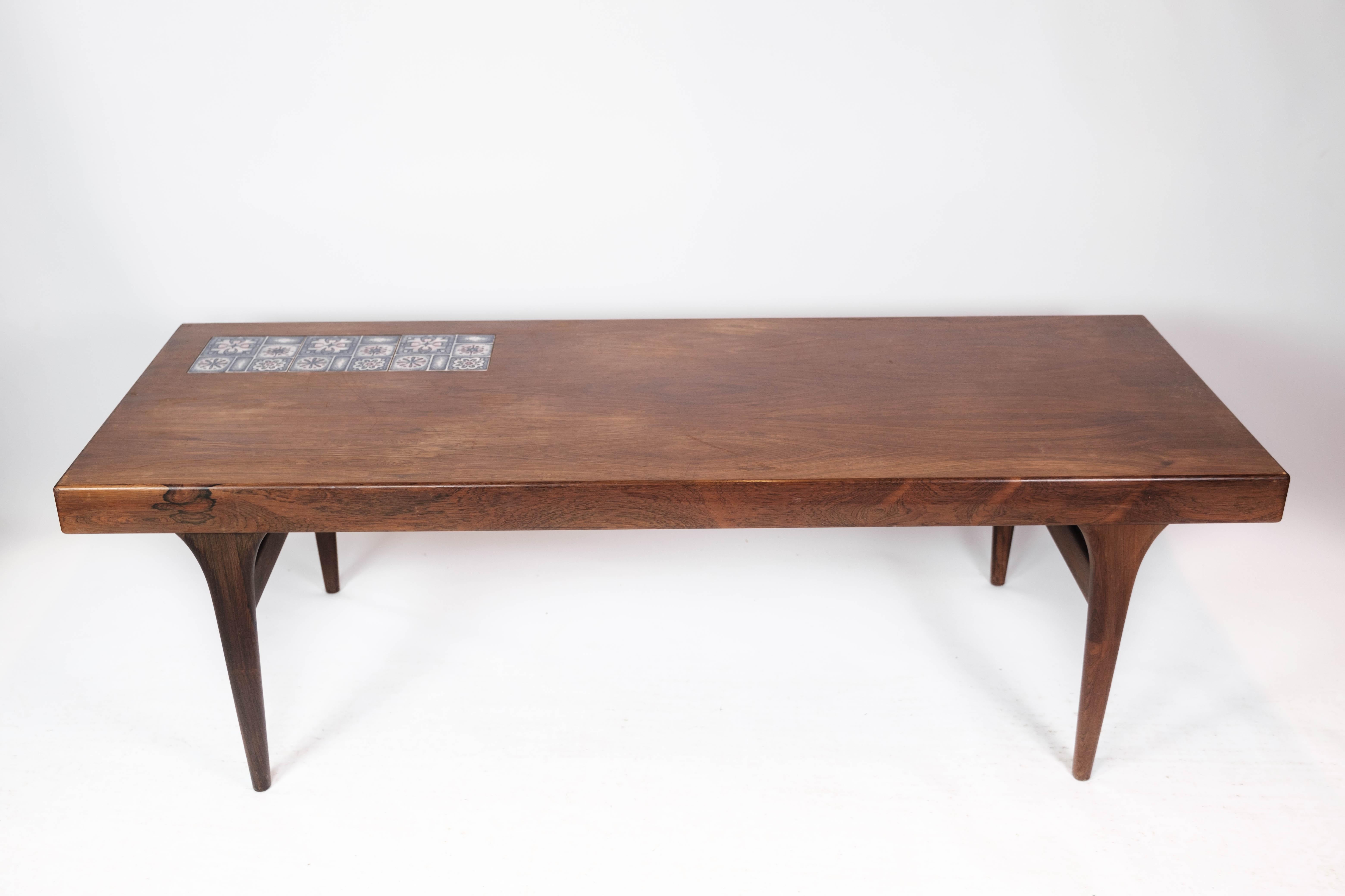 
Cette table basse captivante, fabriquée à partir d'un luxueux bois de rose et ornée de carreaux bleus saisissants, incarne l'esthétique emblématique du design des années 1960. Conçue par le célèbre Johannes Andersen et fabriquée avec expertise par