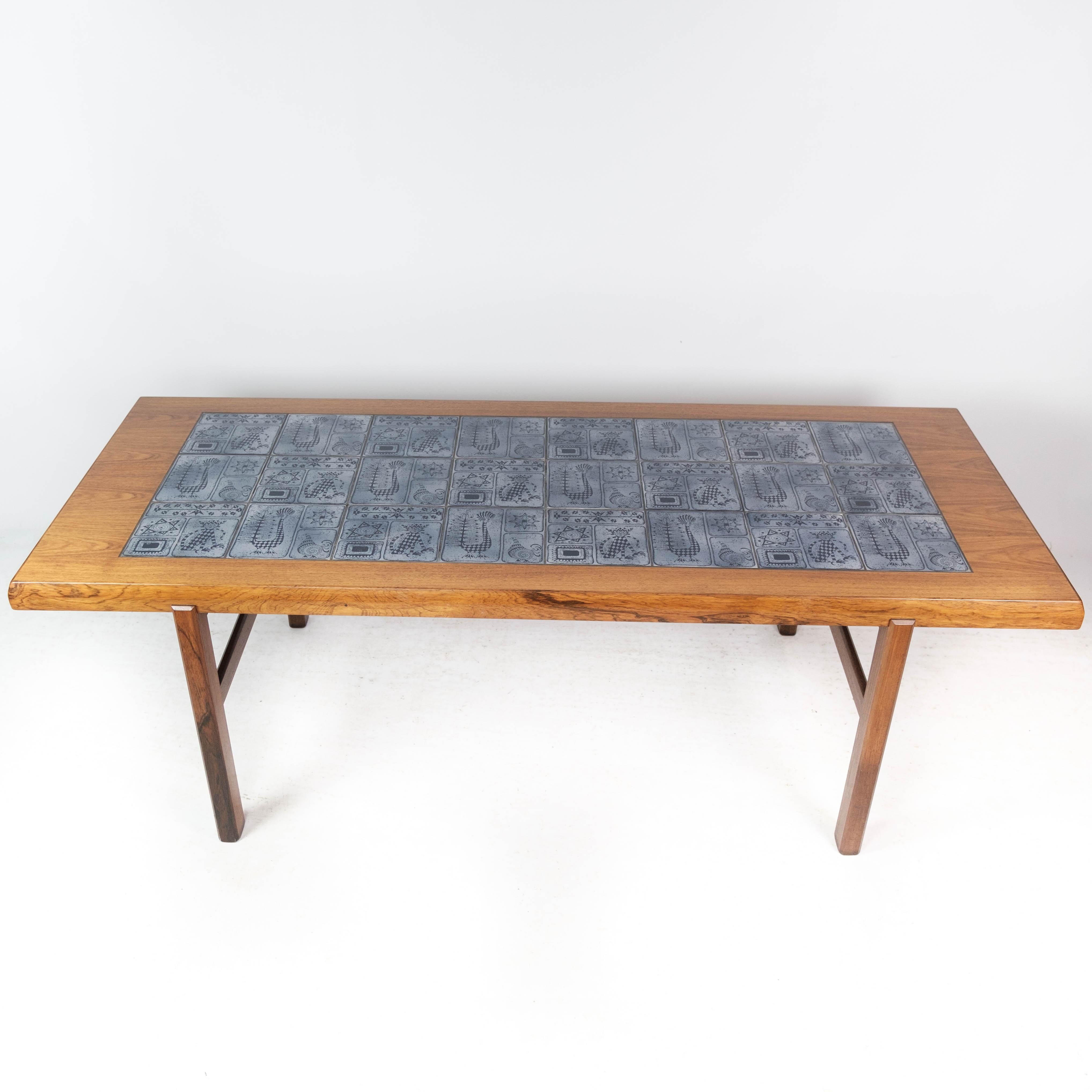 Dieser elegante Couchtisch ist ein beeindruckendes Beispiel für dänisches Design aus den 1960er Jahren, das von Arrebo Furniture mit Präzision und Stil gefertigt wurde. Der Tisch aus luxuriösem Palisanderholz strahlt Wärme und Raffinesse aus und