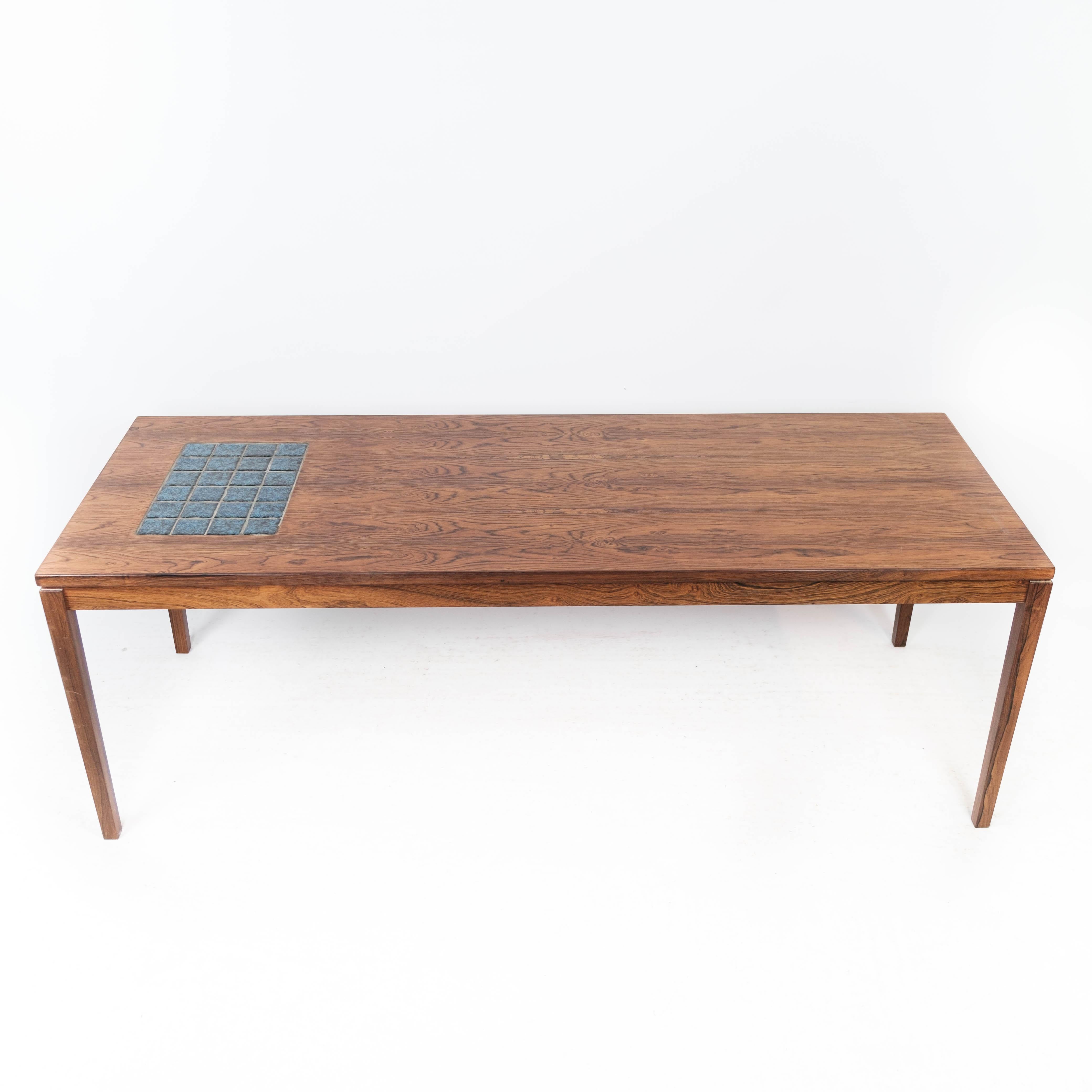 The coffee table in rosewood adorned with blue tiles is a stunning example of Danish design from the 1960s. Characterized by its sleek lines, elegant proportions, and exquisite craftsmanship, this coffee table captures the essence of mid-century