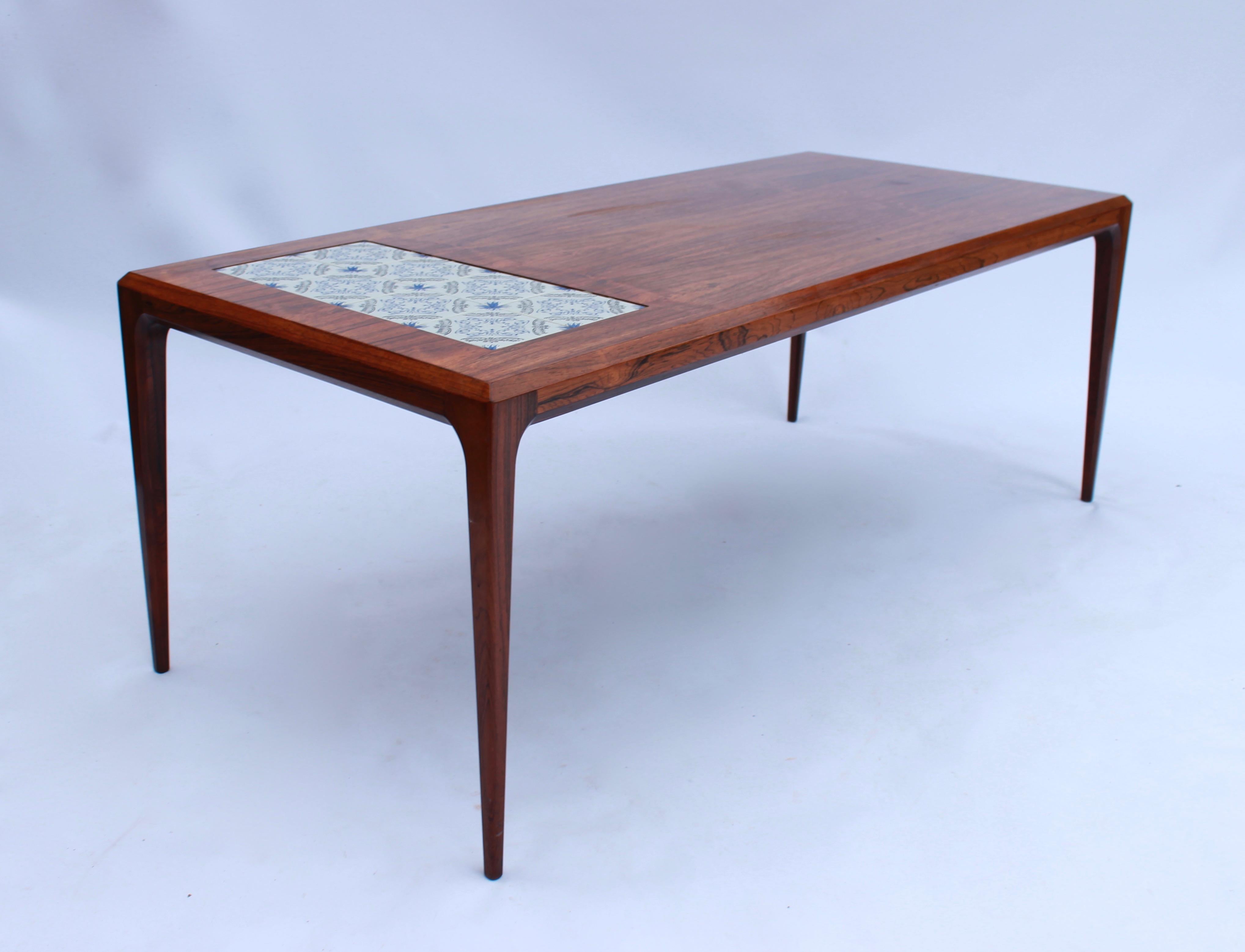 Coffee table in rosewood with Royal Copenhagen tiles designed by Johannes Andersen and manufactured by Silkeborg Furniture factory in the 1960s. The table is in great vintage condition.