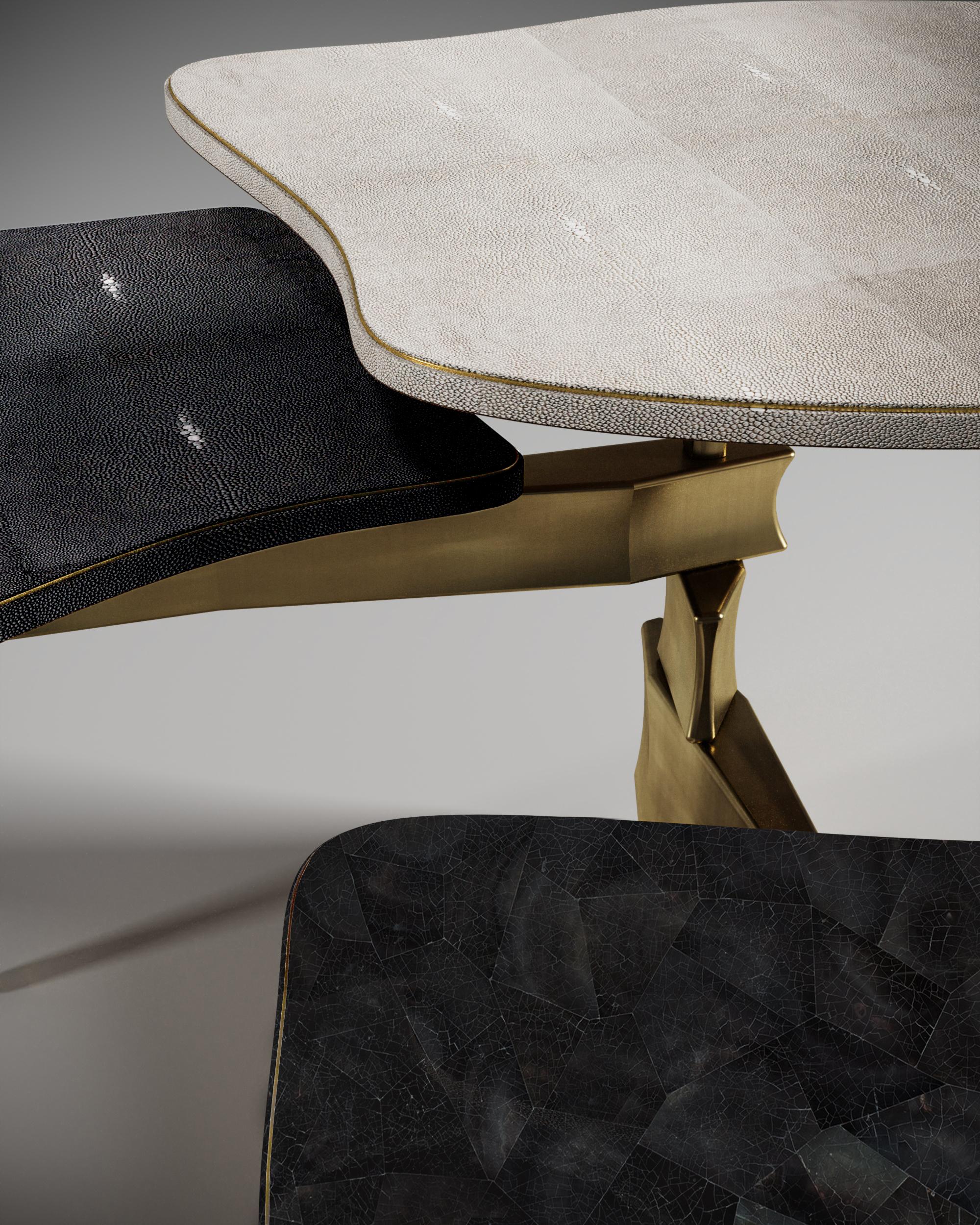 La table basse Metropolis à 3 plateaux de Kifu Paris est un design dramatique et sculptural qui démontre l'incroyable travail artisanal et la signature de ses gènes Augousti. La base en laiton bronze-patiné de la table basse s'inspire