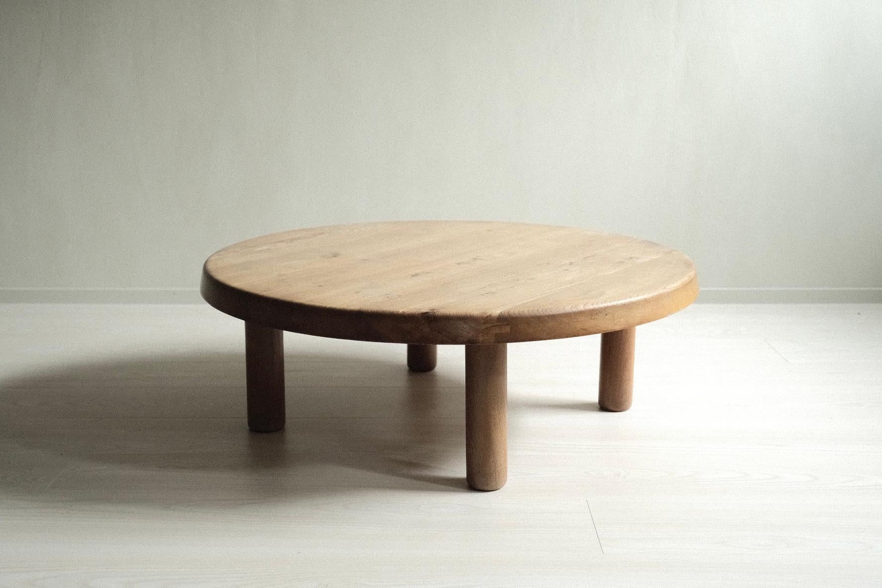 A vintage round coffee table in sold elm by Pierre Chapo, produced in France, c. 1970s. This model no. T02 is in great vintage and original condition.