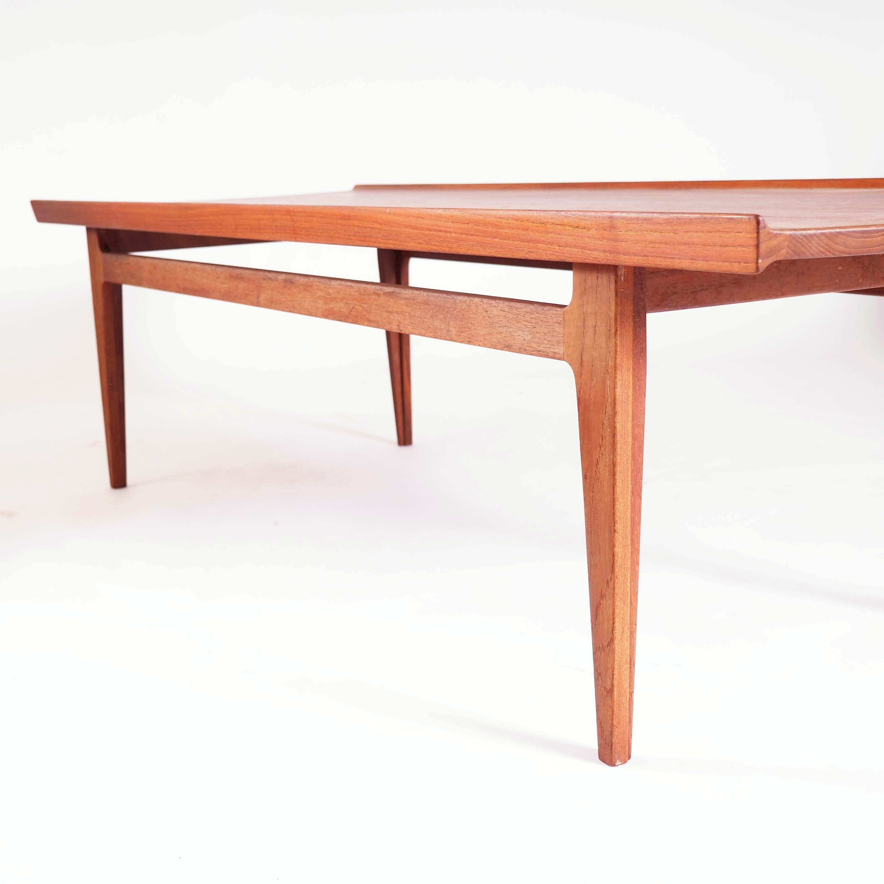 Cette table basse a été conçue par le designer danois Finn Juhl dans les années 1950 et fabriquée par France & Son. La table est en teck massif et de très haute qualité.