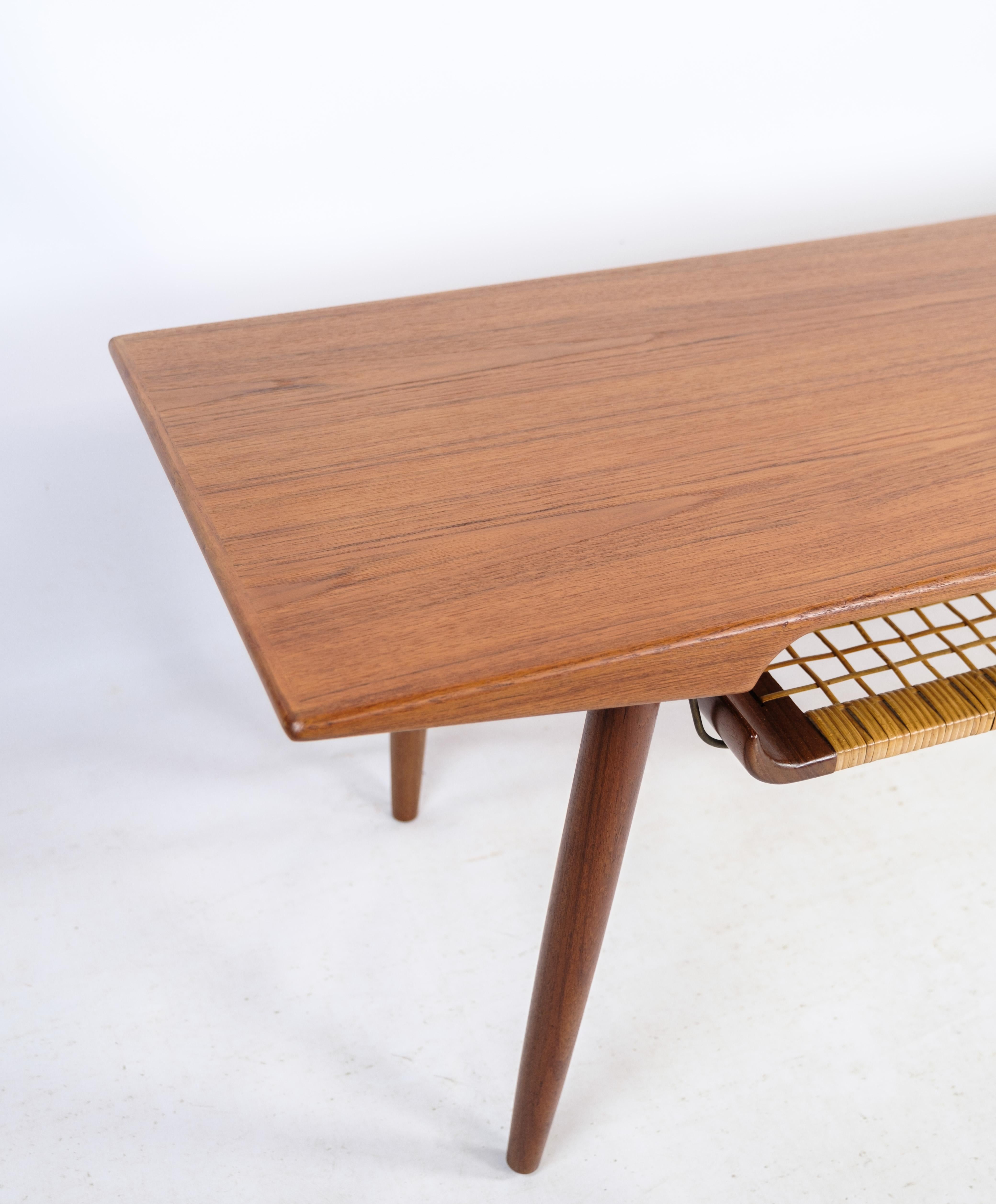 Dieser Couchtisch aus Teakholz mit einer Papierkordelablage ist ein Beispiel für dänisches Design der 1960er Jahre. Der Tisch verbindet die warmen, satten Töne des Teakholzes mit der natürlichen Textur der Papierkordel zu einem harmonischen und