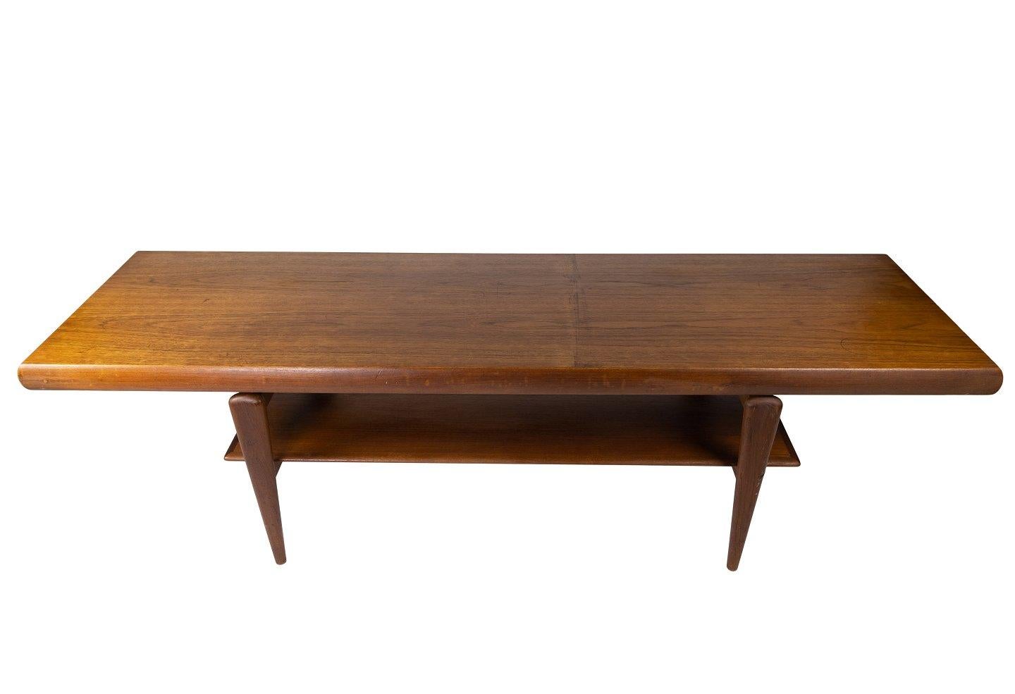 The coffee table, a Danish design from the 1960s, showcases the timeless elegance of teak wood. With its sleek lines and understated sophistication, it epitomizes the mid-century modern aesthetic. This piece seamlessly blends form and function,