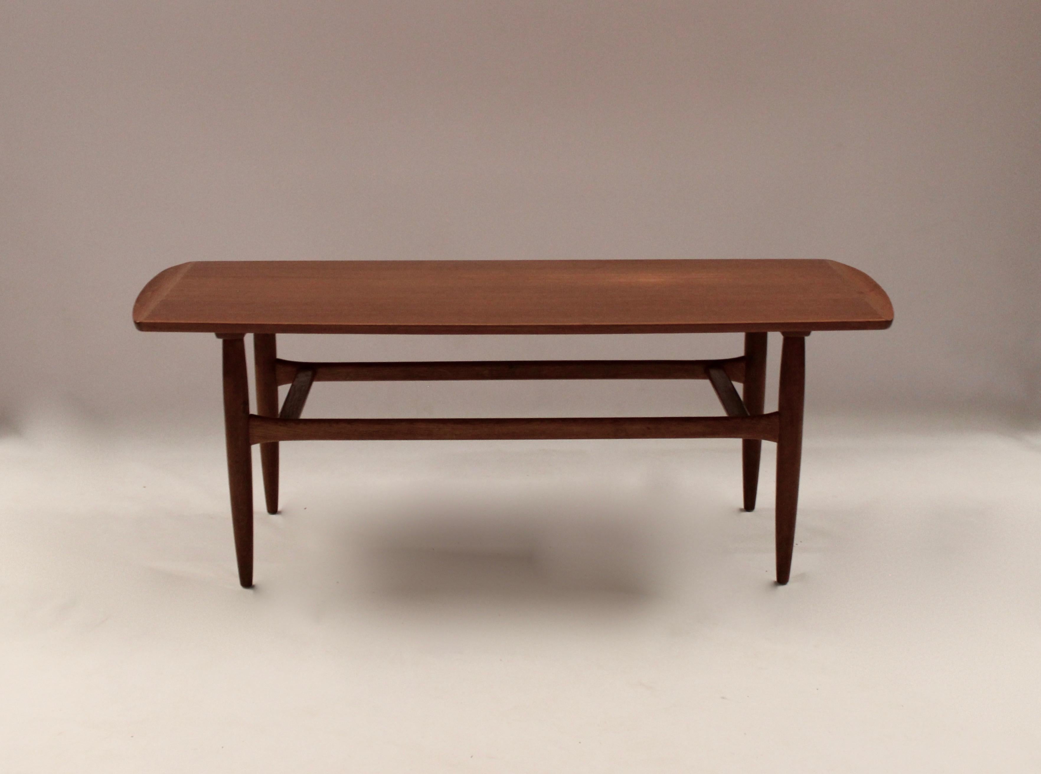 This coffee table is an example of classic Danish design from the 1960s and is made of teak wood, which gives it a warm and inviting appearance. The table has a simple and elegant silhouette that fits perfectly with the period-typical Scandinavian