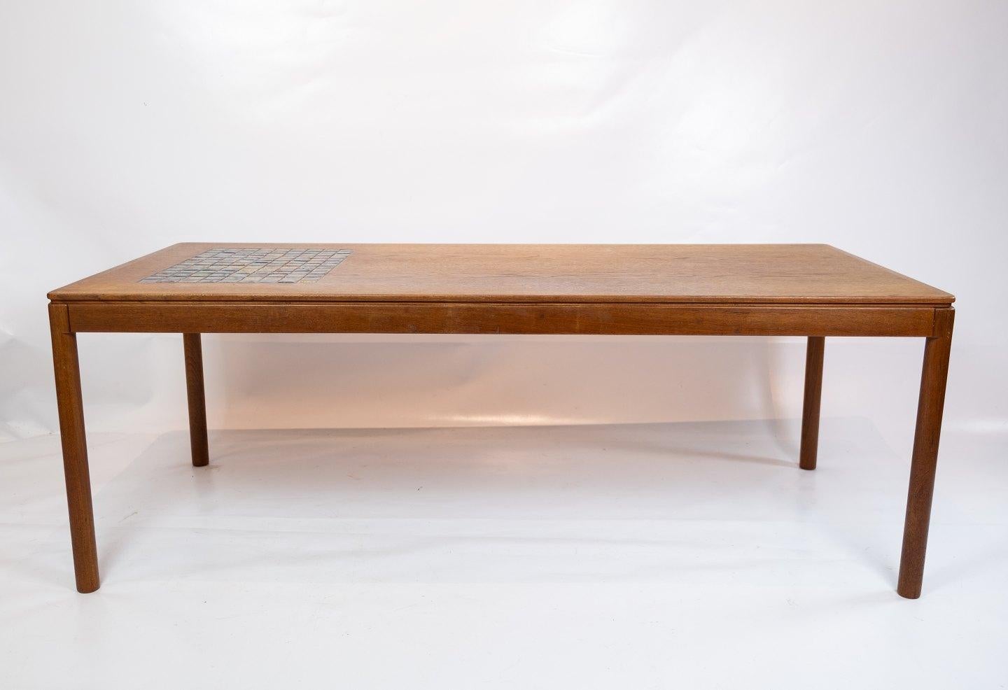 Coffee table in teak with brown ceramic tiles of Danish design from the 1960s. The table is in great vintage condition.
         
This coffee table, crafted in teak with brown ceramic tiles, embodies the essence of Danish design from the 1960s.