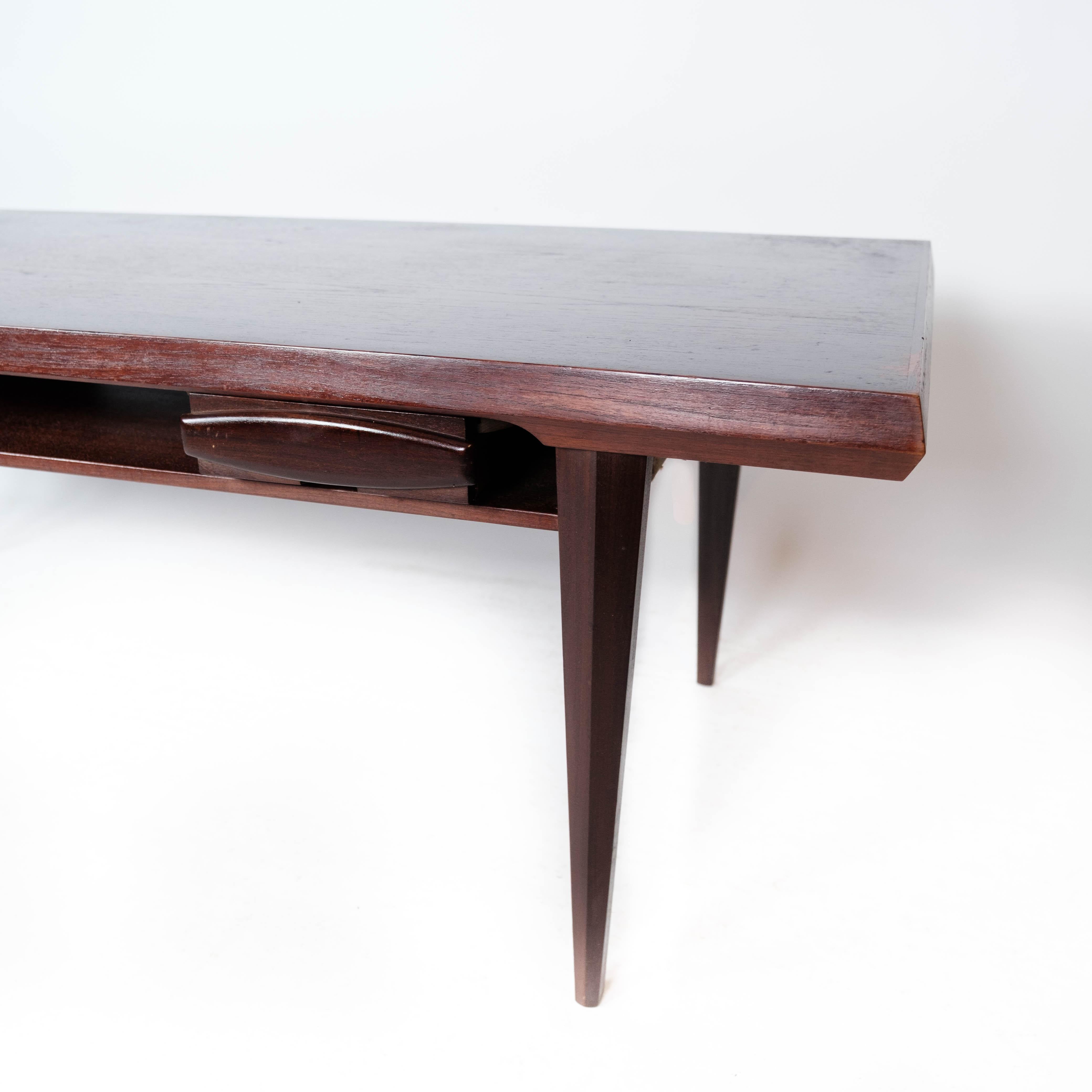 La table basse fabriquée en teck et reprenant le design danois des années 1960 est un remarquable mélange d'élégance et de fonctionnalité.

Le teck, réputé pour sa durabilité et ses tons chauds, confère une certaine sophistication à la table. Les