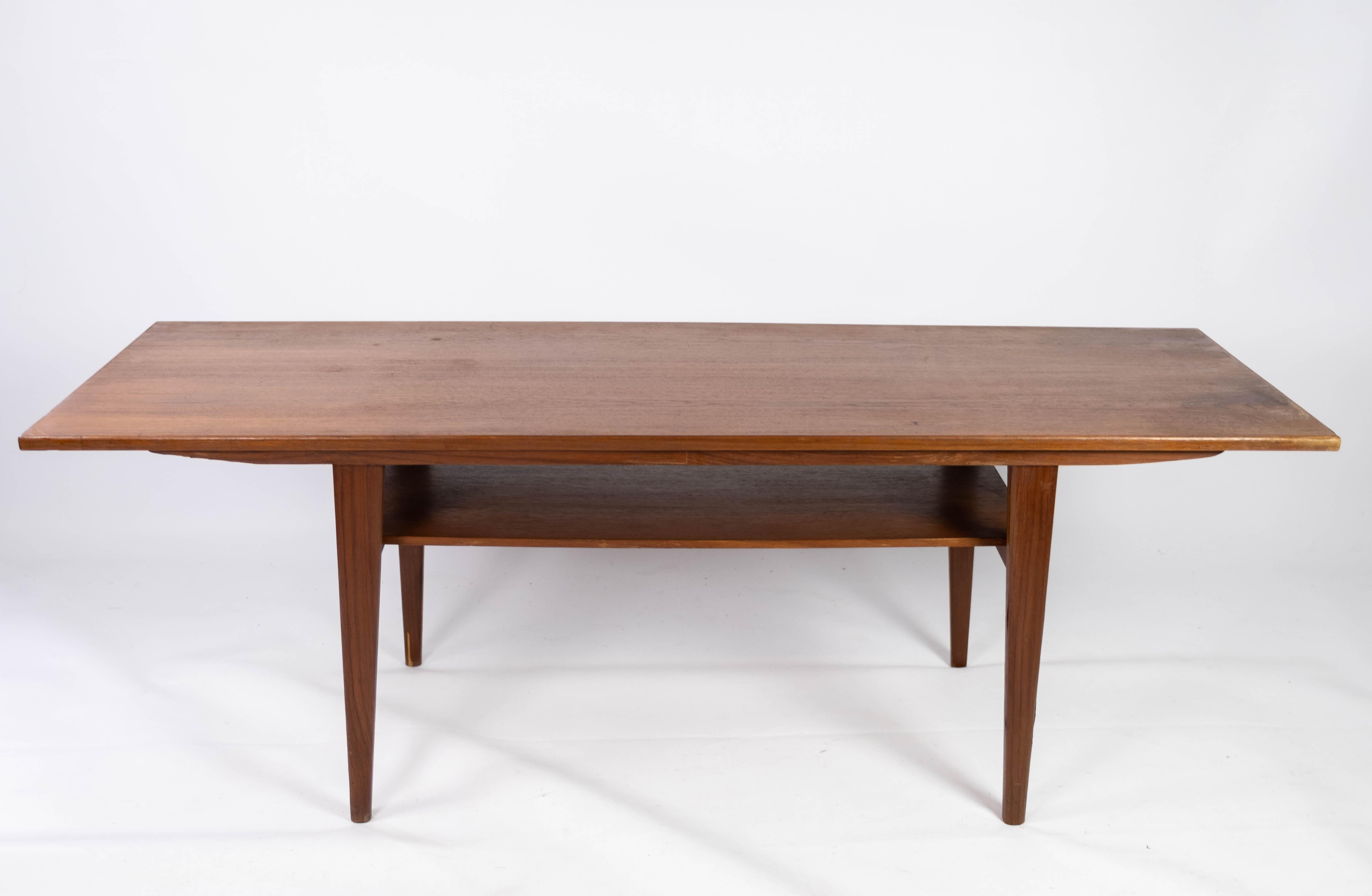 This teak coffee table, a product of Danish design from the 1960s, epitomizes the elegance and functionality characteristic of mid-century modern furniture. Crafted with precision and attention to detail, it seamlessly blends form and function,