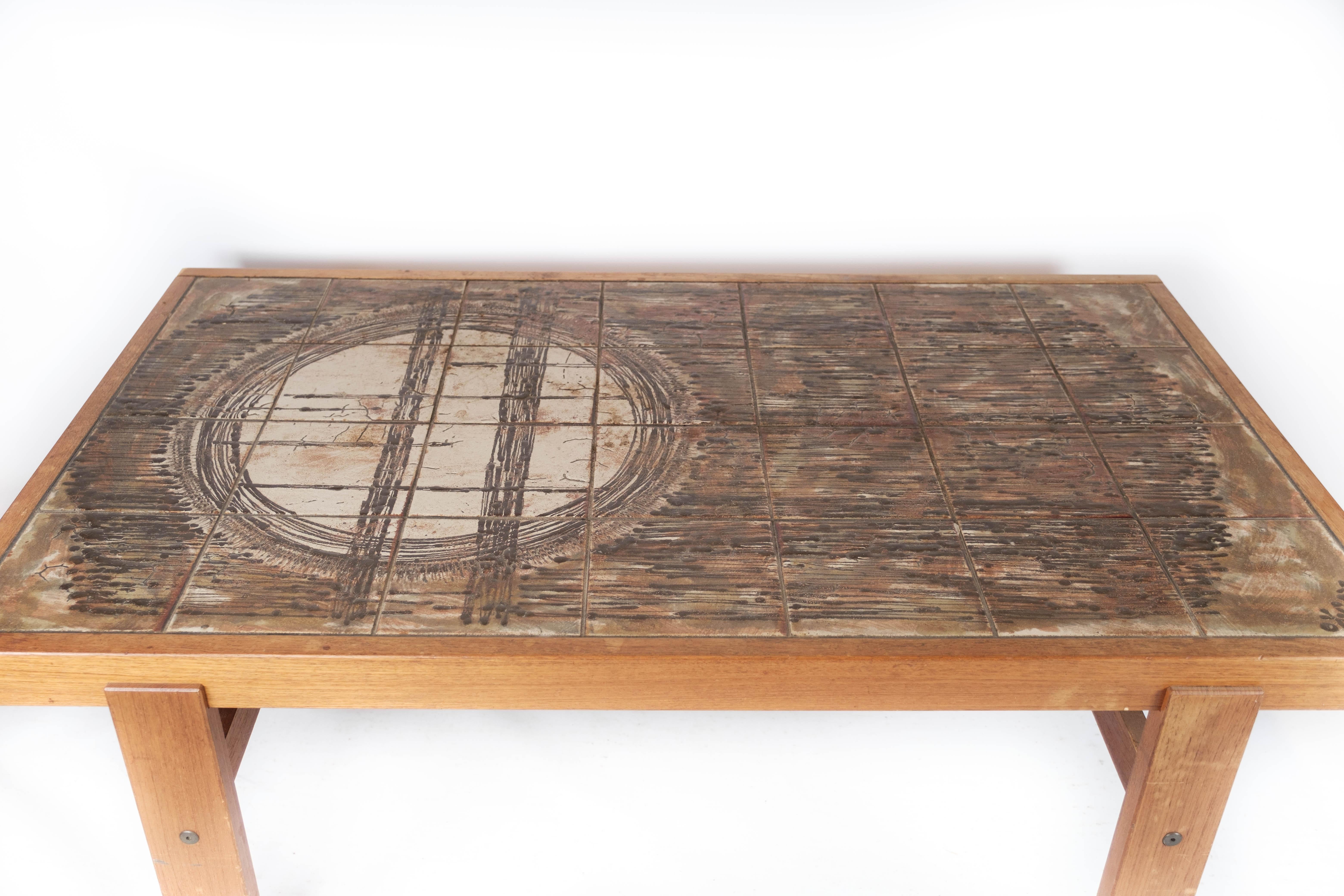 Fabriquée en bois de teck et ornée de charmants carreaux, cette table basse capture l'essence du design des années 1960. Ses lignes épurées et sa silhouette minimaliste incarnent l'esthétique danoise emblématique de l'époque, alliant fonctionnalité