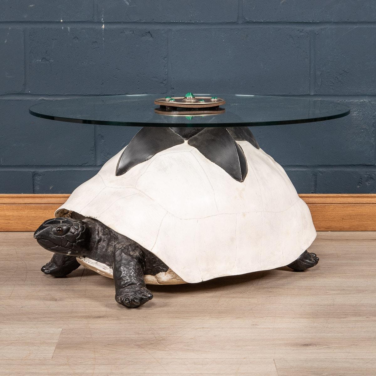 A coffee table by Anthony Redmile, London, circa 1970. The base of the table fashioned from composite painted turtle, the central circular plaque inlaid with hardstone cabochons signed Redmile, London to the centre. Anthony Redmile burst into the