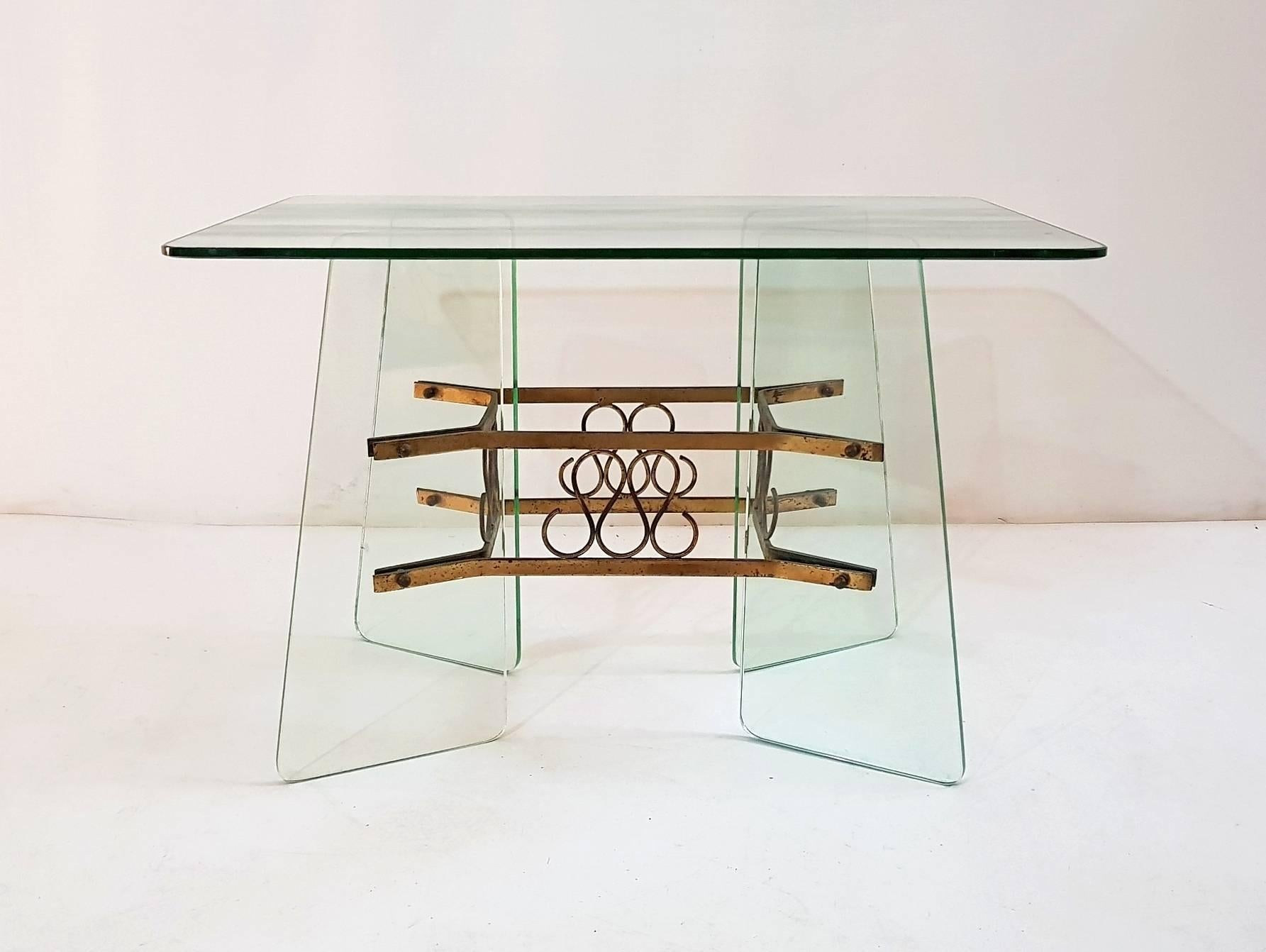 Coffee table in the manner of Fontana Arte 

The table has a glass top and four glass feet connected by a brass structure. The table has two minor chippings but they don't affect the look or quality.