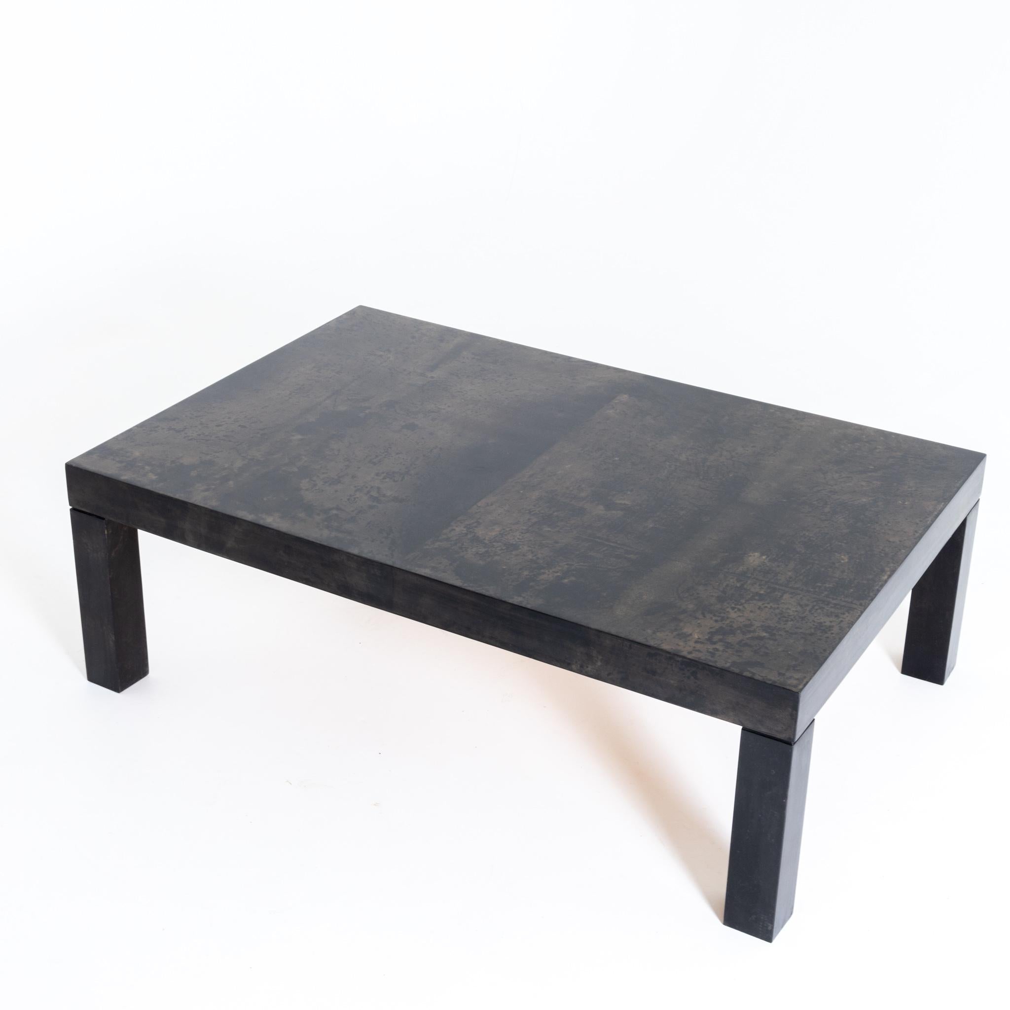 Rectangular coffee table on square legs and lacquered goat skin as surface.