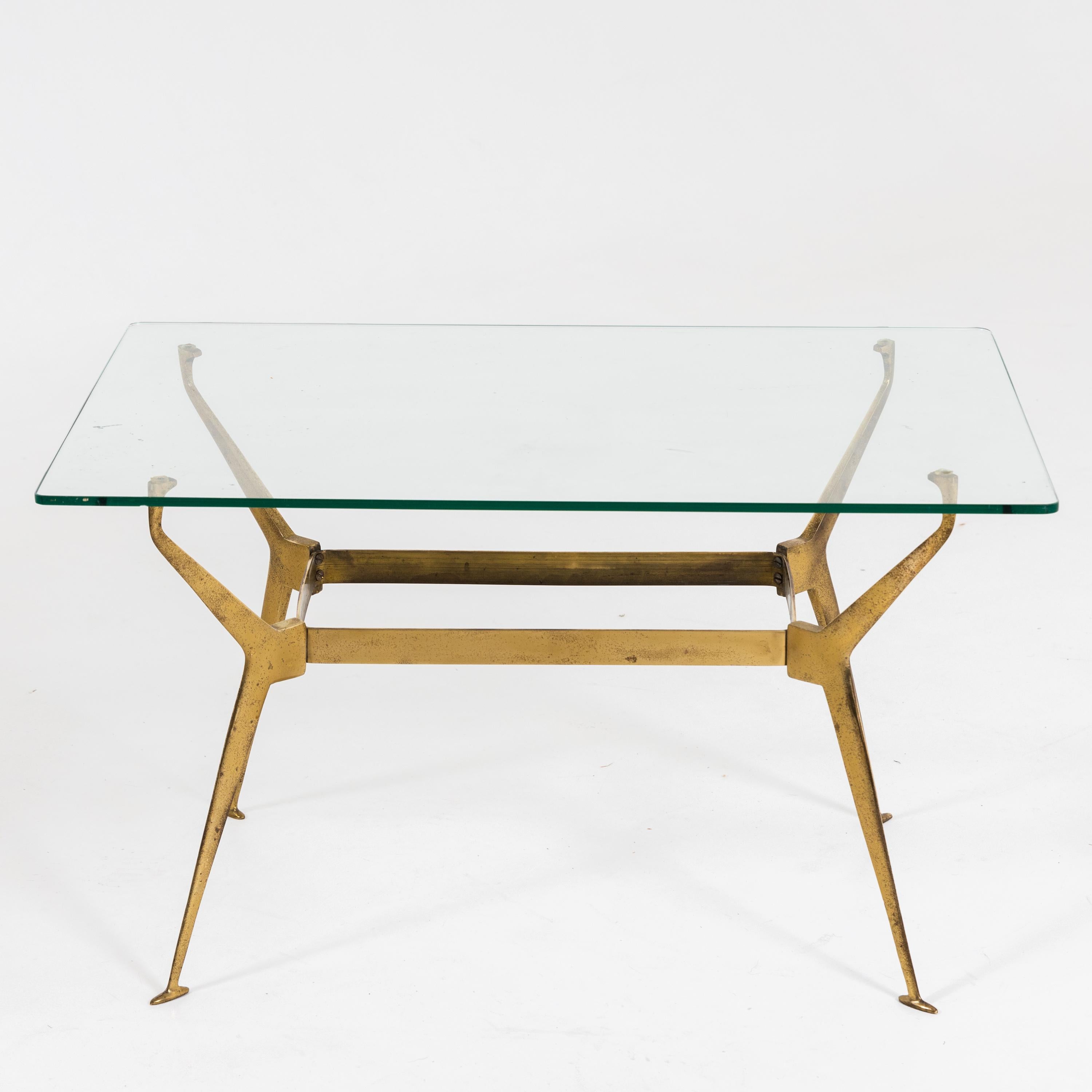 Coffee table with rectangular glass top on delicate brass frame.