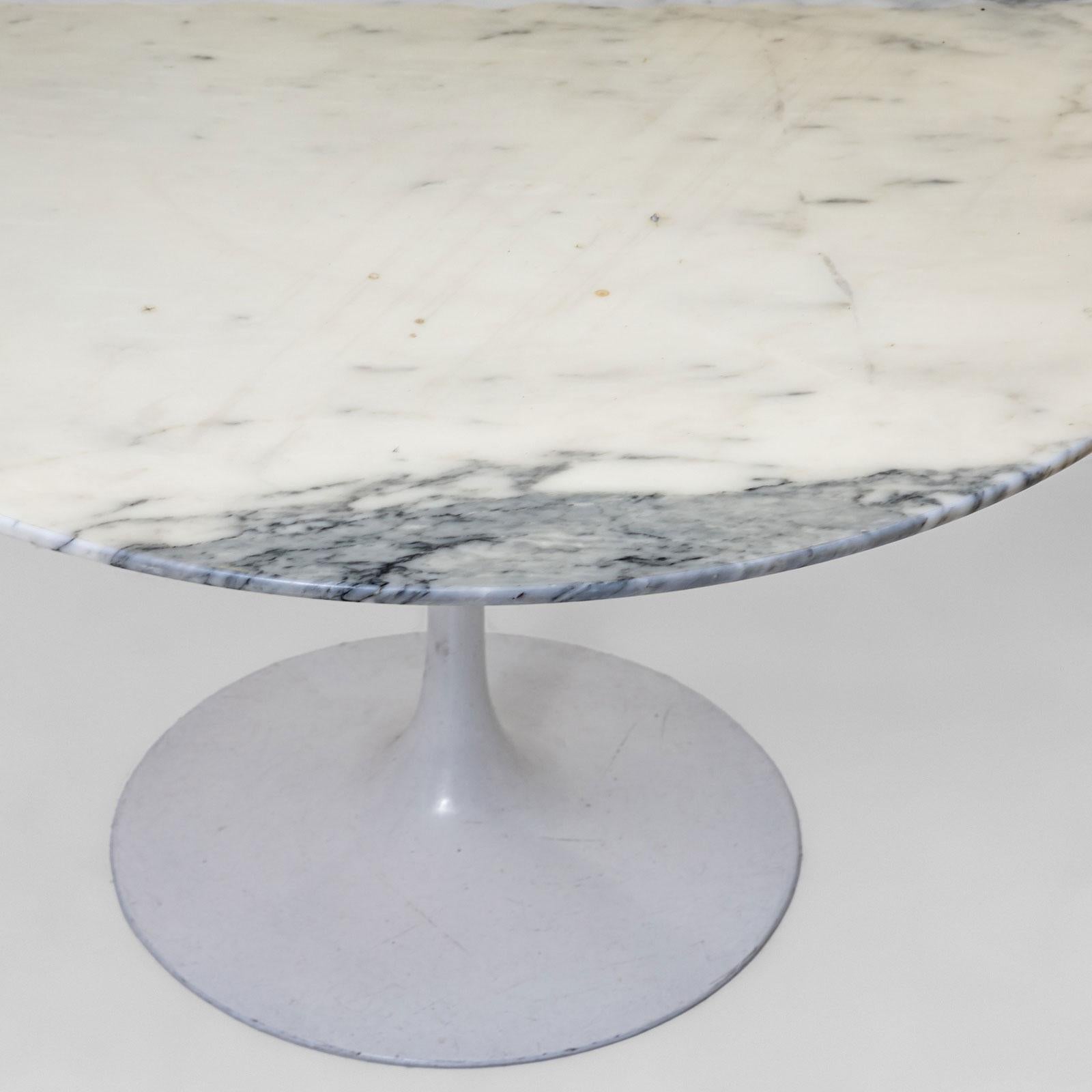 An elegant coffee table in the style of the iconic Tulip Table by Eero Saarinen. The table features a trumpet-shaped base with a white lacquered finish and a round tabletop made of white marble with striking black veining. A timeless design piece